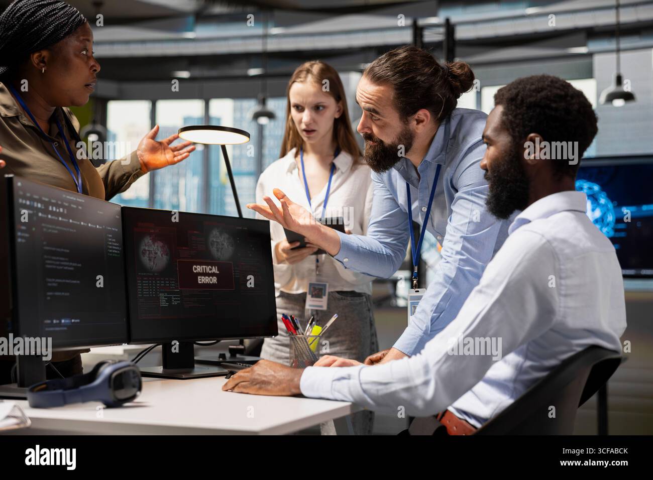 Gli sviluppatori di software collaborano, risolvendo gli avvisi di errore critico visualizzati sullo schermo nell'ufficio di avvio tecnico, risolvendo gli avvisi di sistema. Dipendenti IT che utilizzano il PC per riparare i bug delle apparecchiature per ufficio Foto Stock