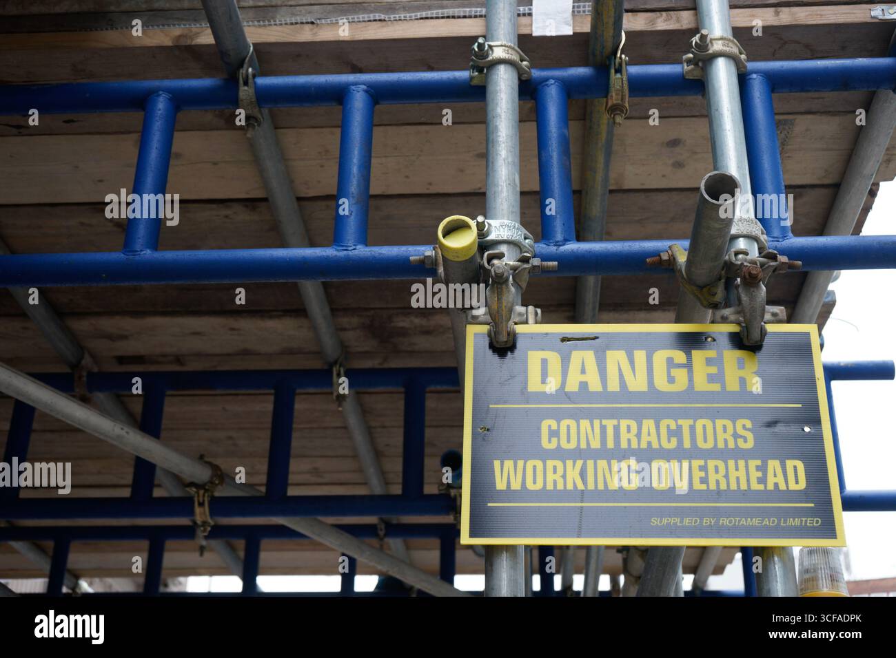 LONDRA, REGNO UNITO. 5 SETTEMBRE 2016. Un cartello di avvertimento giallo sul ponteggio per lavori edili avverte i pedoni che gli appaltatori lavorano in testa in una strada cittadina Foto Stock