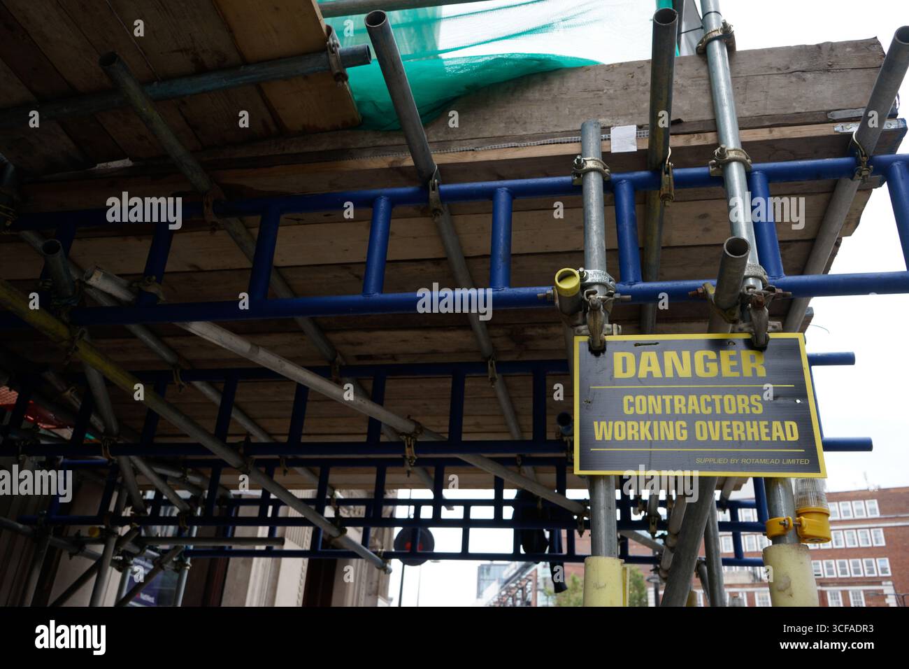 LONDRA, REGNO UNITO. 5 SETTEMBRE 2016. Un cartello di avvertimento giallo sul ponteggio per lavori edili avverte i pedoni che gli appaltatori lavorano in testa in una strada cittadina Foto Stock