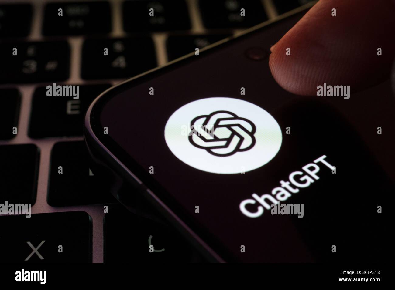 Icona dell'app ChatGPT sullo smartphone con il dito che tocca lo schermo sulla tastiera. Stafford, Regno Unito, 21 agosto 2025 Foto Stock