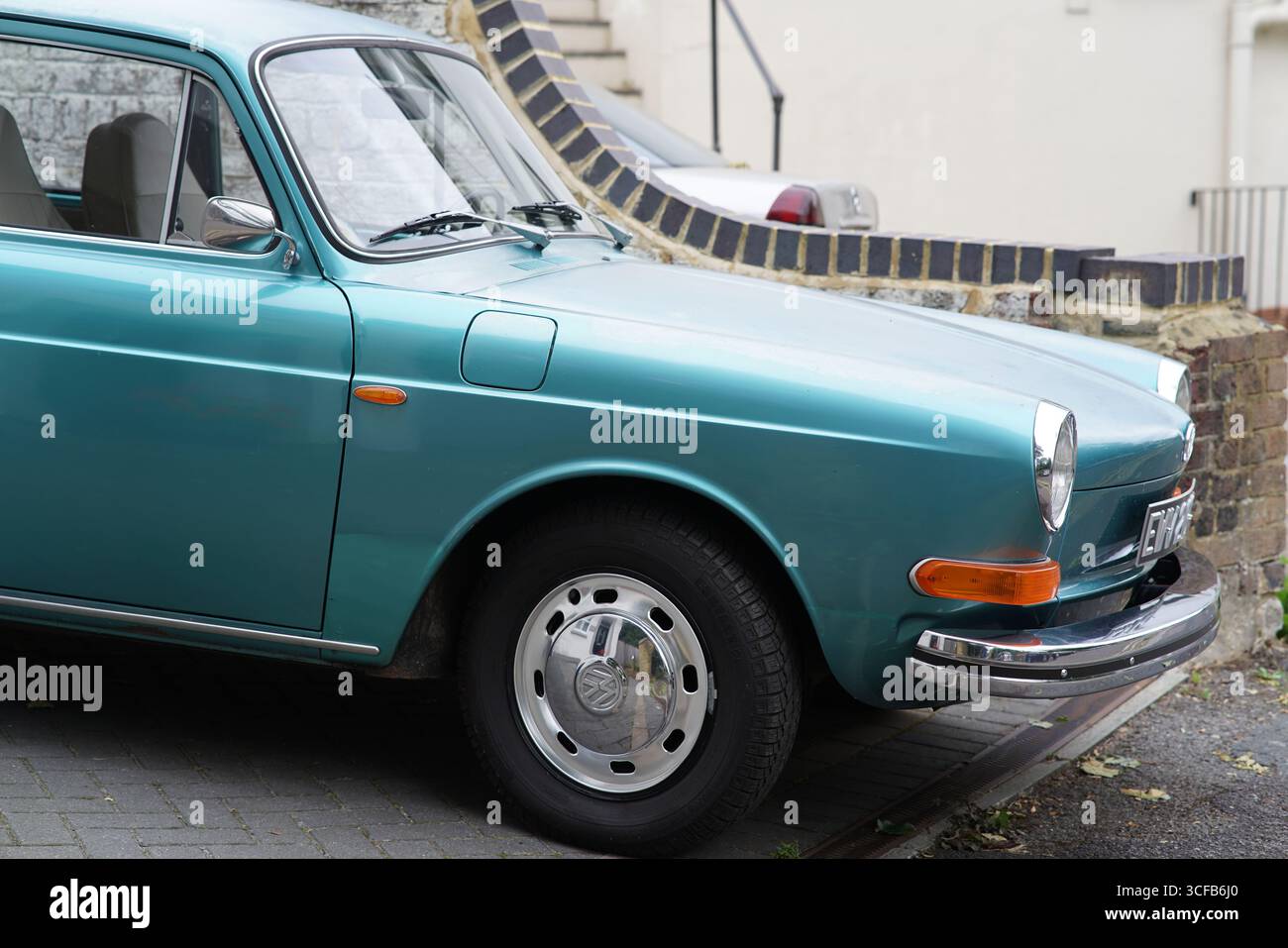 Auto d'epoca verde parcheggiata accanto a Brick Wall in un giorno di sole. Redhill, Inghilterra Foto Stock
