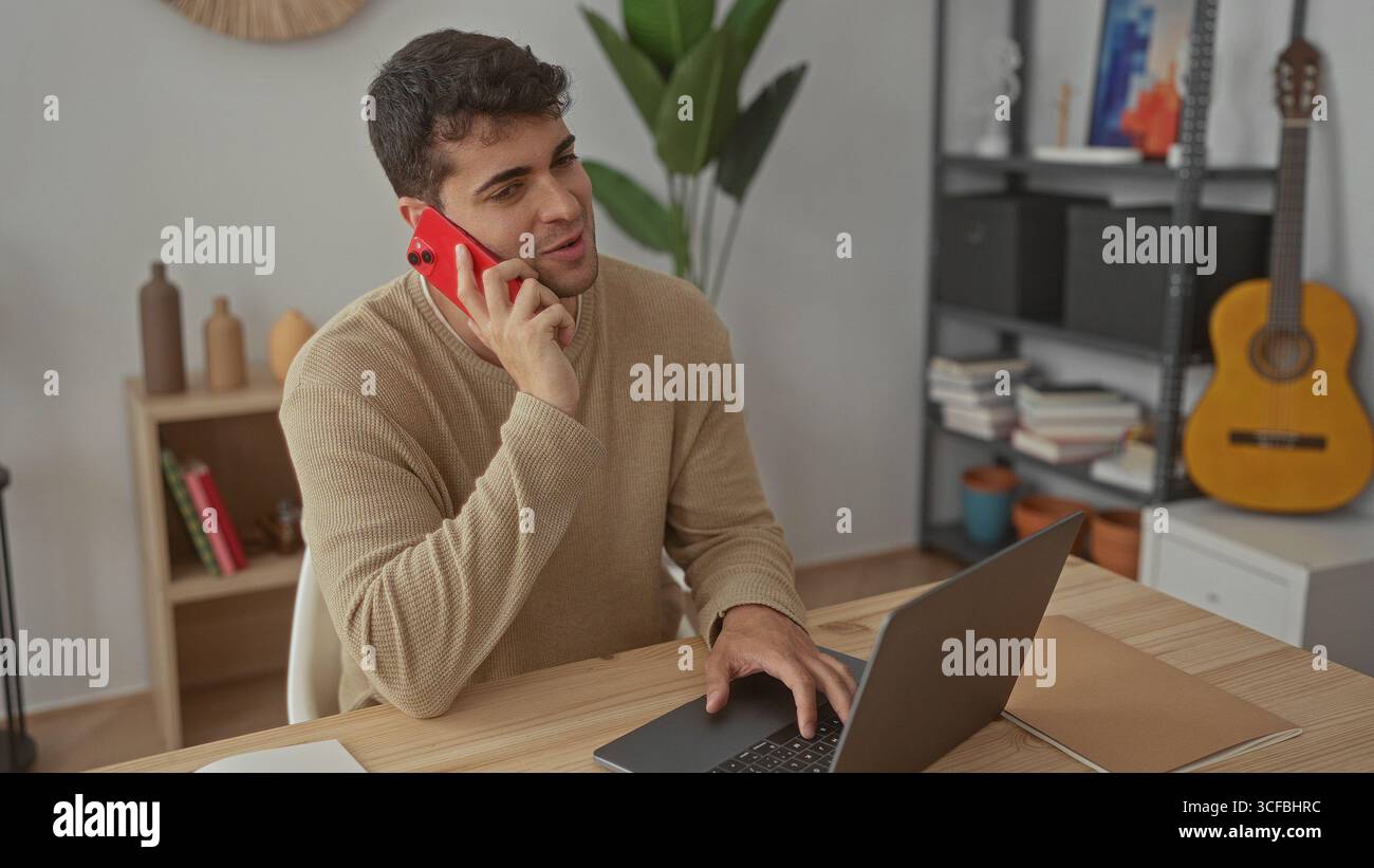L'uomo afferra il telefono per parlare a casa mentre il giovane ispanico cerca il laptop sulla scrivania accanto allo smartphone prima di chiamare. Foto Stock