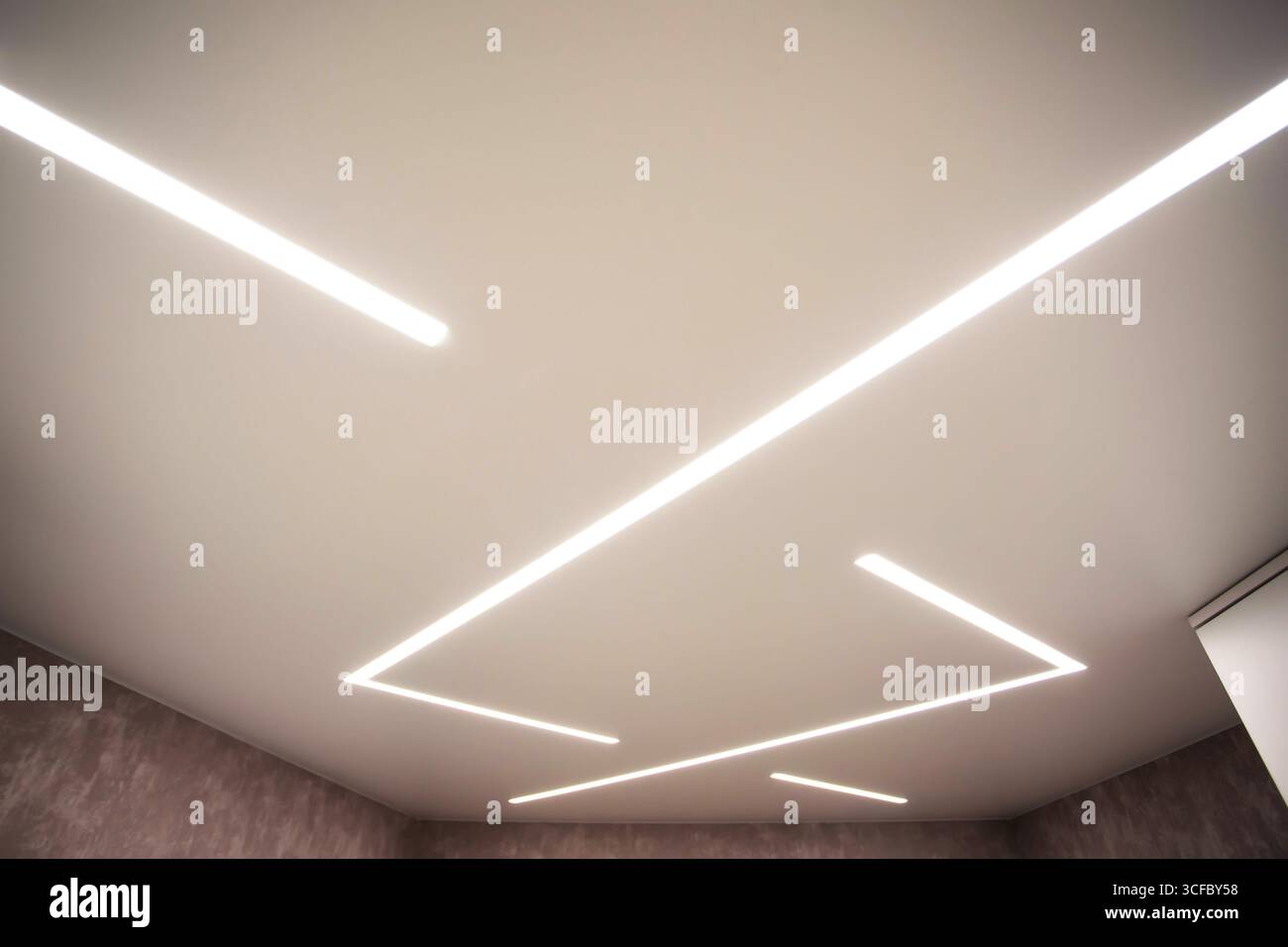 Soffitto allungato moderno ed elegante con linee luminose a LED. Foto Stock