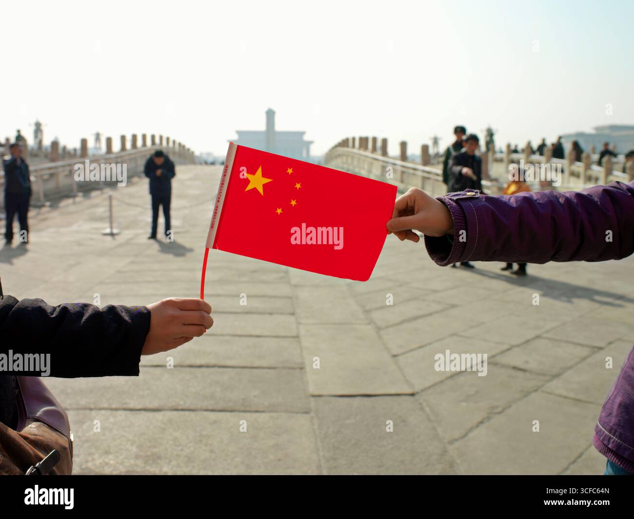 Mani che tengono la bandiera cinese Foto Stock