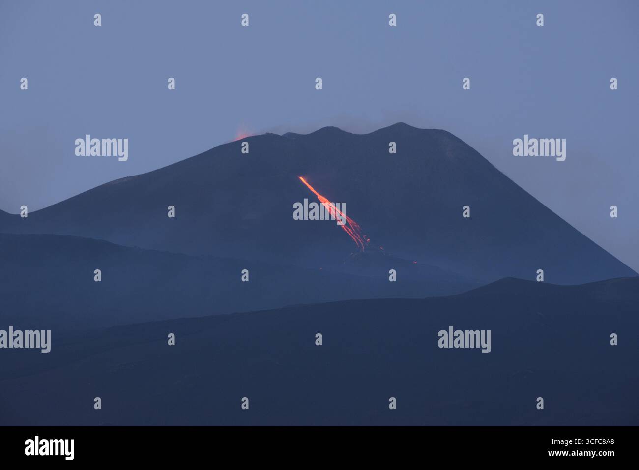 Nell'agosto del 2025 l'Etna entrò in una fase effusiva alimentata da bocche tra bocca nuova e il cratere sudorientale a ~2.980–3.200 m s.l.m., inviando freschi corsi di lava lungo la base del cratere sudorientale e sui fianchi sudovest/occidentali superiori. Le immagini mostrano turisti curiosi e gruppi guidati che osservano i flussi luminosi e le esplosioni stromboliane intermittenti al cratere sudorientale, con piccole scogliere di cenere e pennacchi di gas che si disperdono rapidamente. Altri sfiati annotati il 20 e il 21 agosto, con flussi che avanzano da sud a sud-ovest attraverso l'area della cima. Foto Stock