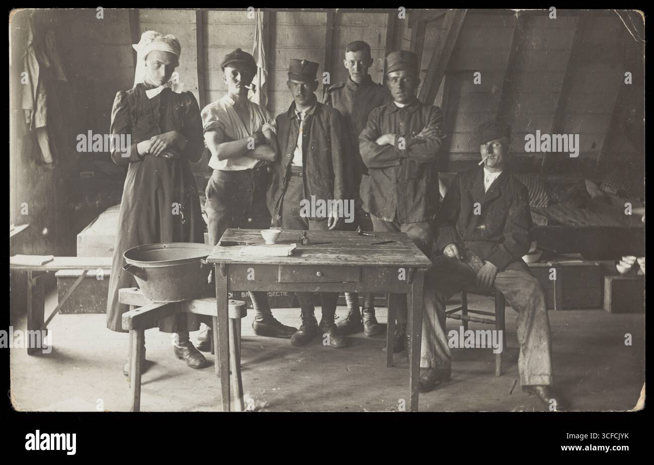 I prigionieri di guerra francesi, uno a trascinamento, si riuniscono intorno a un piccolo tavolo di legno, [tra il 1910 e il 1919?]. Foto Stock