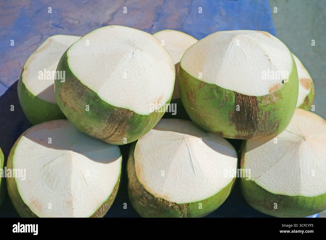 Mucchio di noci di cocco giovani fresche tagliate nella forma da aprire per bere Foto Stock