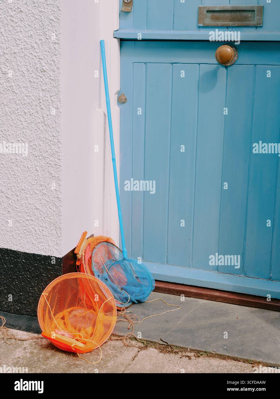 Due colorate reti da pesca per bambini alle porte di una casa vacanze al mare - vacanza estiva estiva in famiglia nel regno unito Foto Stock