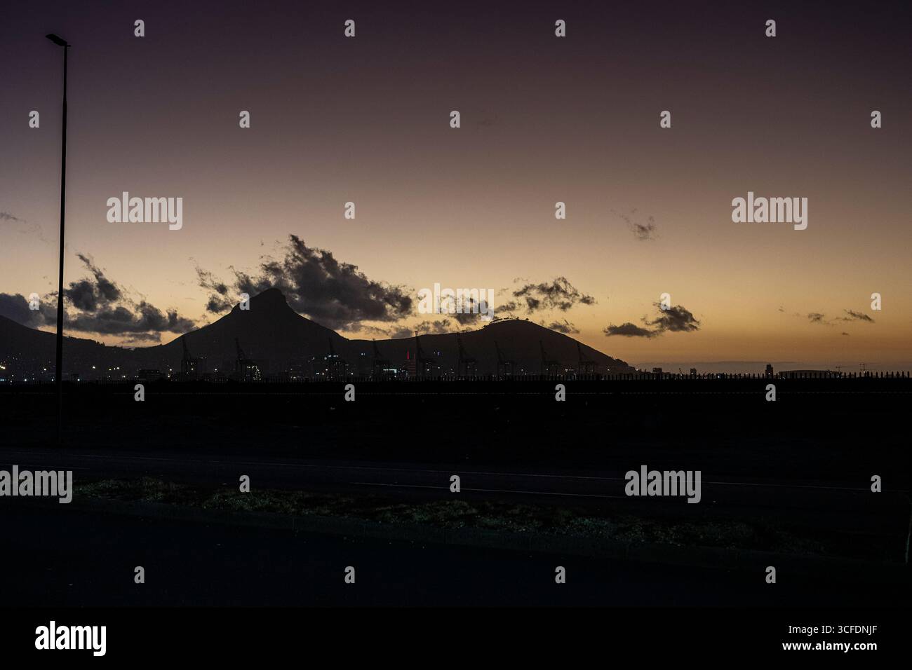 Tramonto a città del Capo guardando verso il porto di città del Capo e Table Mountain, la città e il porto e il porto alla base delle montagne Foto Stock