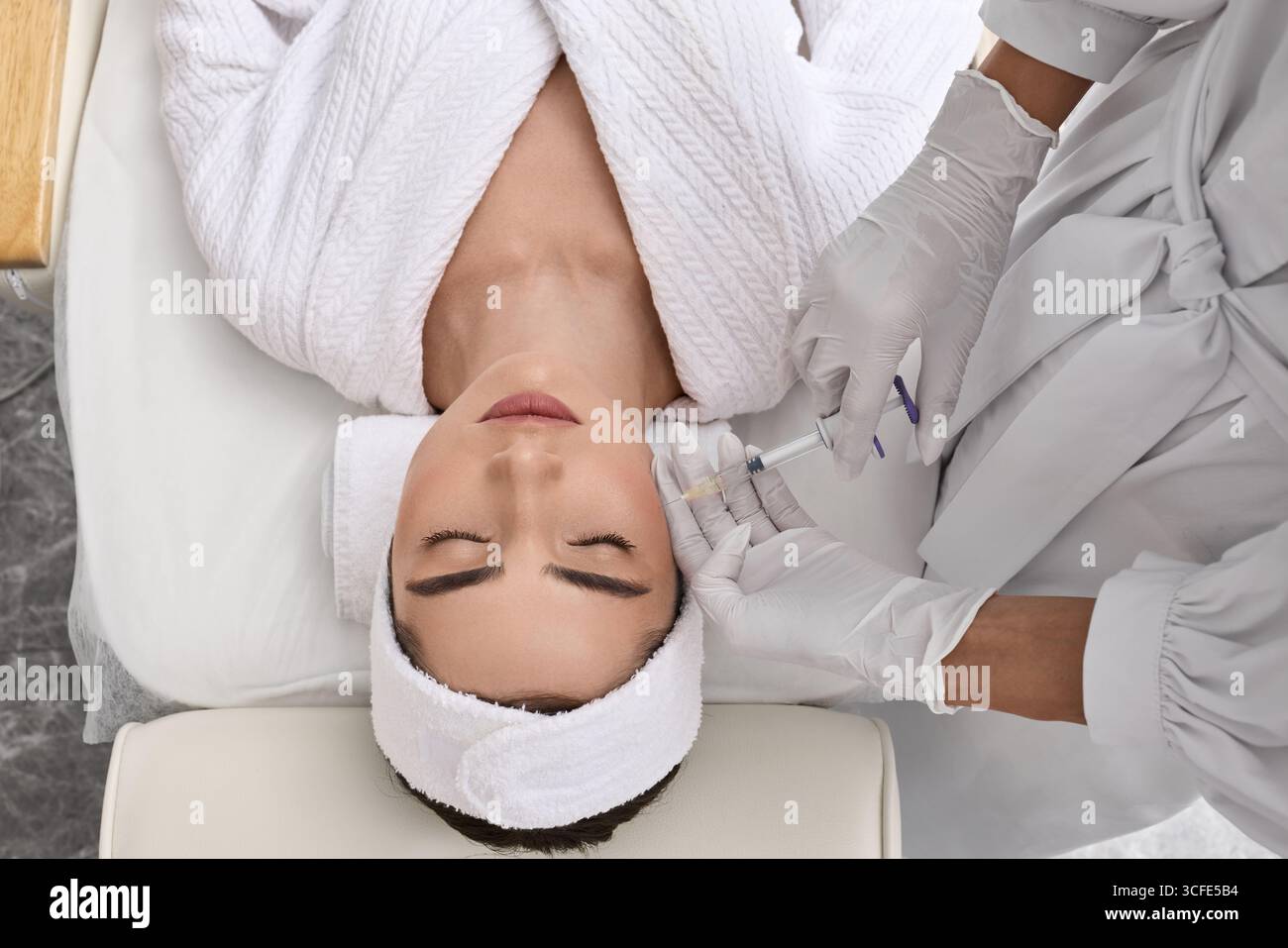 Biorevitalizzazione. Bella donna ottenere iniezioni di bellezza con acido ialuronico per lisciare il viso imita rughe. Procedura anti-invecchiamento Foto Stock