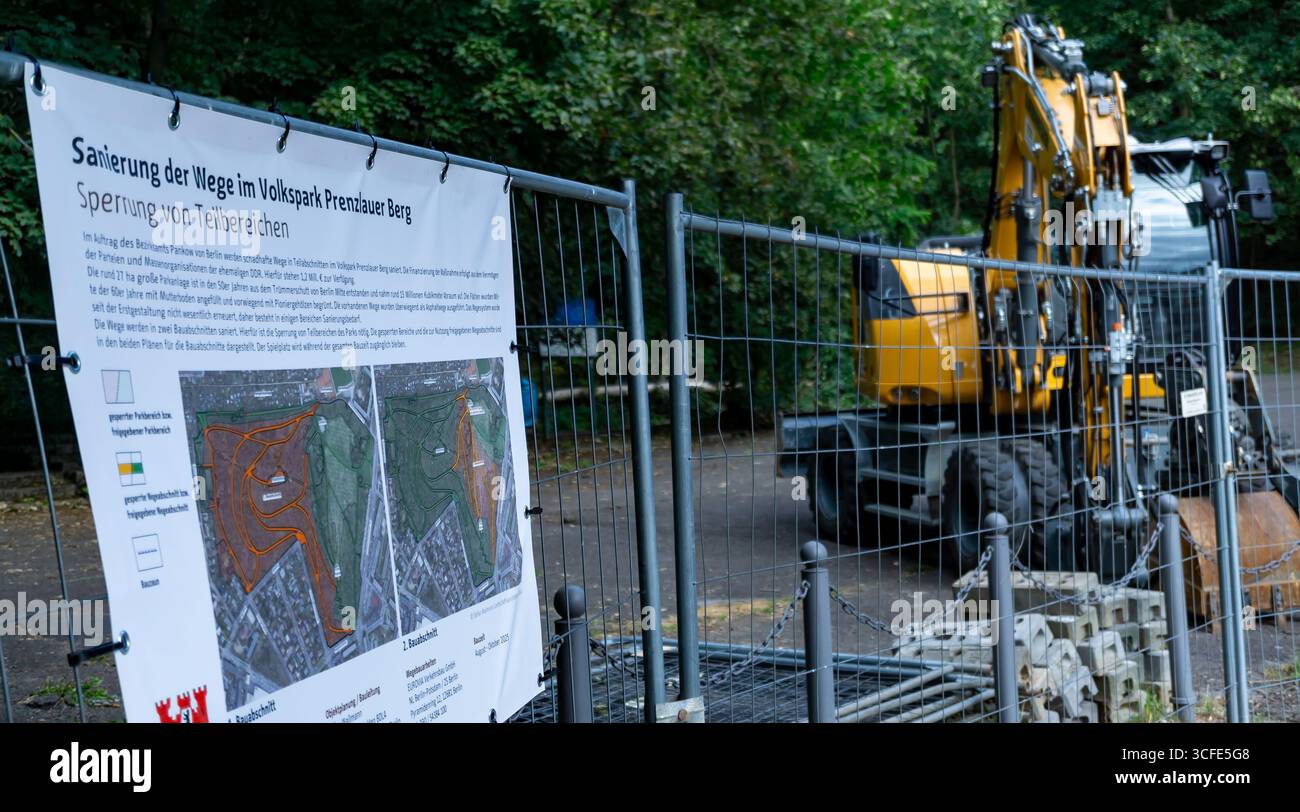 Insegna di ristrutturazione presso Volkspark Prenzlauer Berg con macchinari per l'edilizia in background Foto Stock