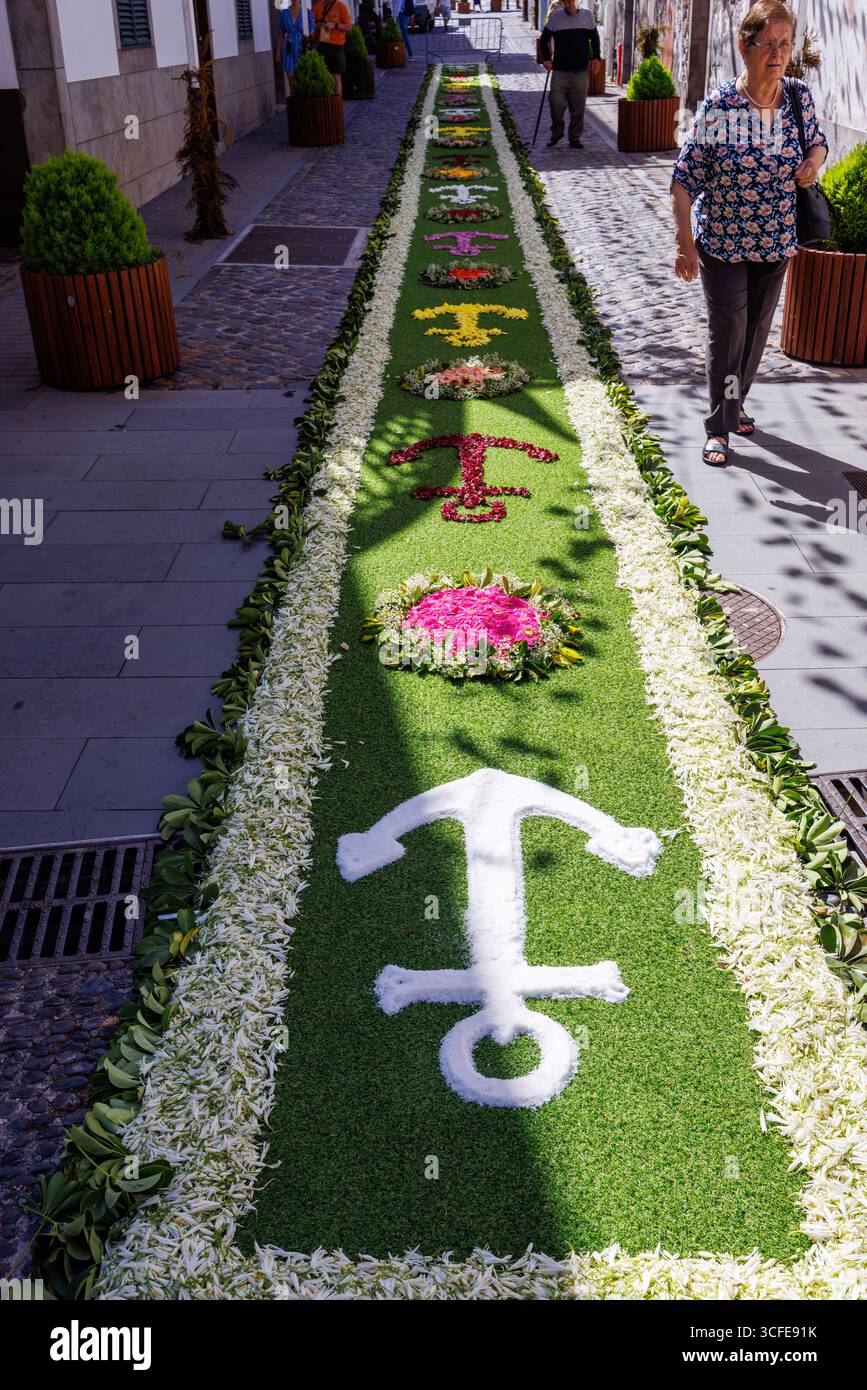 Camara de Lobos, Madeira, Portogallo - 07 luglio 2025; lungo tappeto floreale con un simbolo di speranza - un'ancora addossata di fiori. Foto di alta qualità Foto Stock