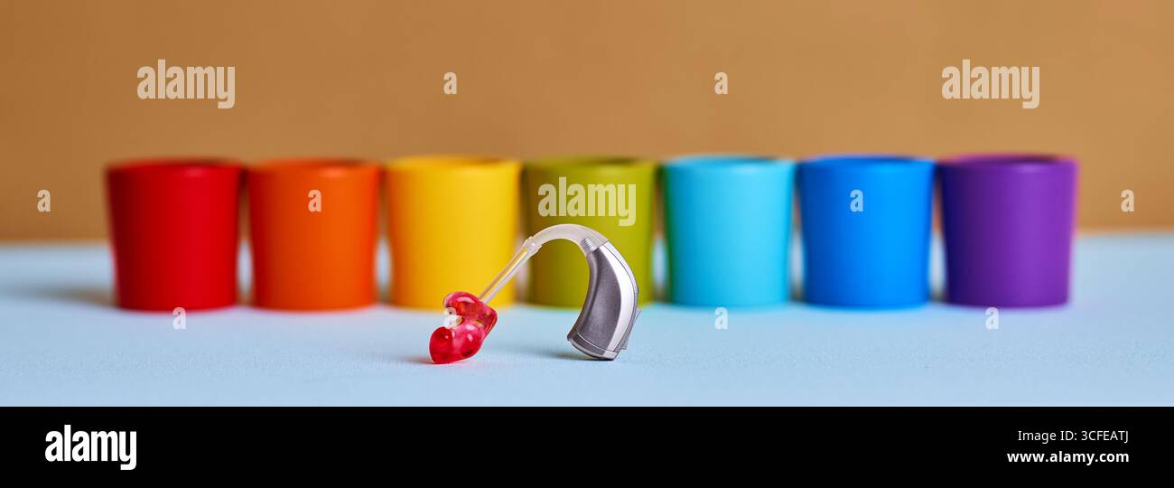 L'apparecchio acustico per bambini si distingue, promuovendo la salute uditiva e l'inclusione tra i giocattoli colorati. Perdita dell'udito nei bambini Foto Stock