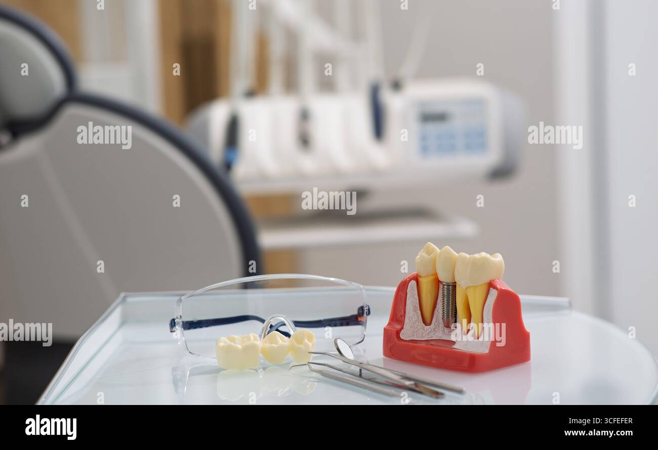 La sedia dentale è dotata di strumenti e modelli di denti, pronti per la consultazione del paziente in un ambiente pulito. Odontoiatria Foto Stock