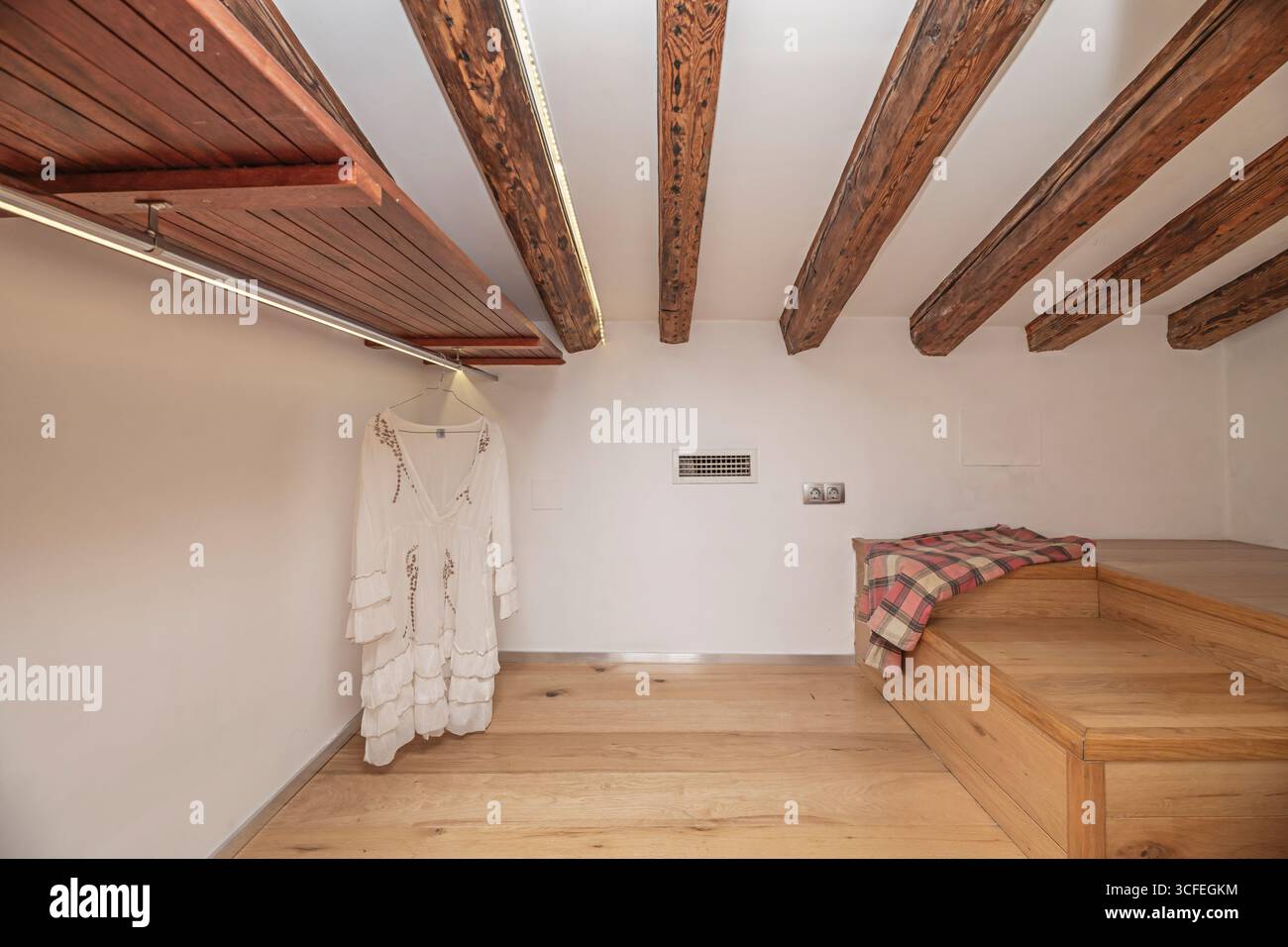 Una camera da letto immersa nella storia dove travi secolari di noce creano una baldacchino naturale sullo spazio vuoto, pronto per la decorazione Foto Stock