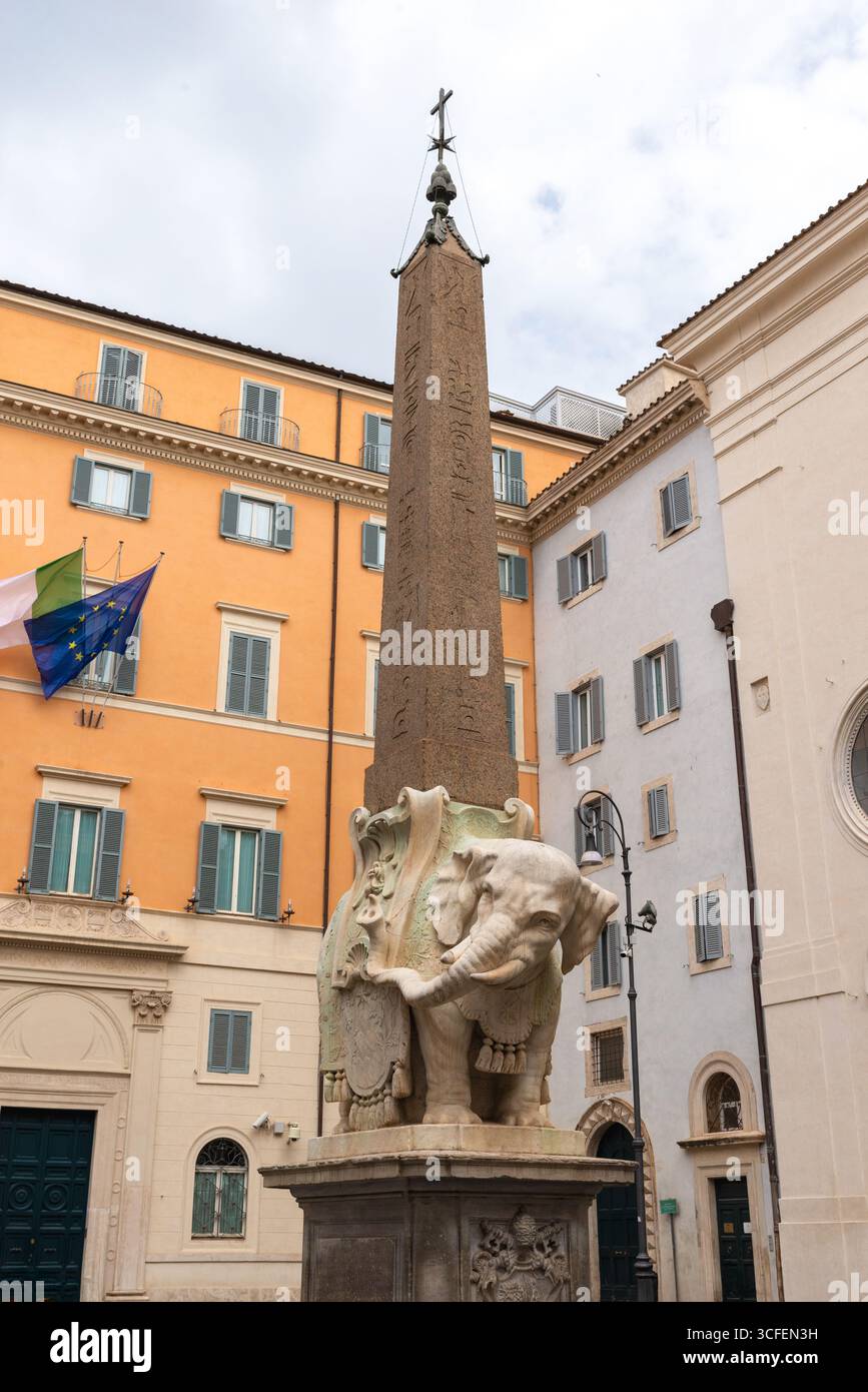Antico obelisco montato su scultura di elefante nel centro di Roma, in Italia, circondato da edifici storici Foto Stock