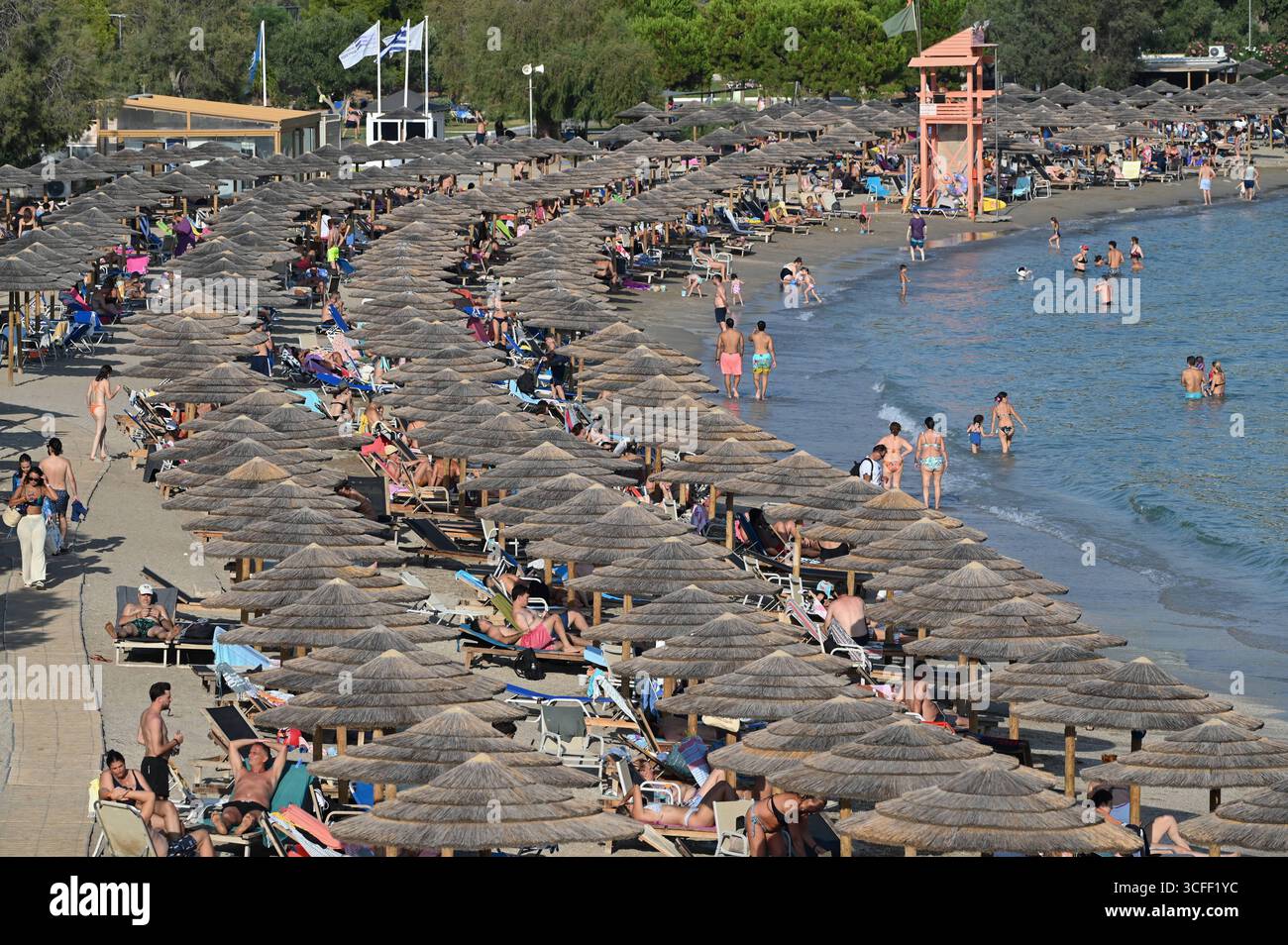 Folle di persone si recano sulle spiagge mentre una mini ondata di calore colpisce Atene folle di persone cercano di rinfrescarsi sulla spiaggia di Vouliagmeni vicino ad Atene mentre una mini ondata di calore colpisce la Grecia. Atene Grecia Copyright: XNicolasxKoutsokostasxNicolasxKoutsokostasx DSC 202508220506 Foto Stock