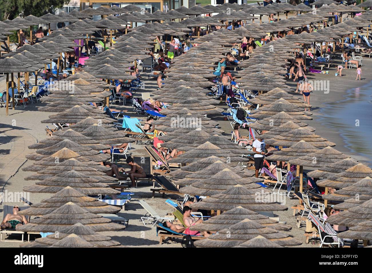 Folle di persone si recano sulle spiagge mentre una mini ondata di calore colpisce Atene folle di persone cercano di rinfrescarsi sulla spiaggia di Vouliagmeni vicino ad Atene mentre una mini ondata di calore colpisce la Grecia. Atene Grecia Copyright: XNicolasxKoutsokostasxNicolasxKoutsokostasx DSC 202508220483 Foto Stock