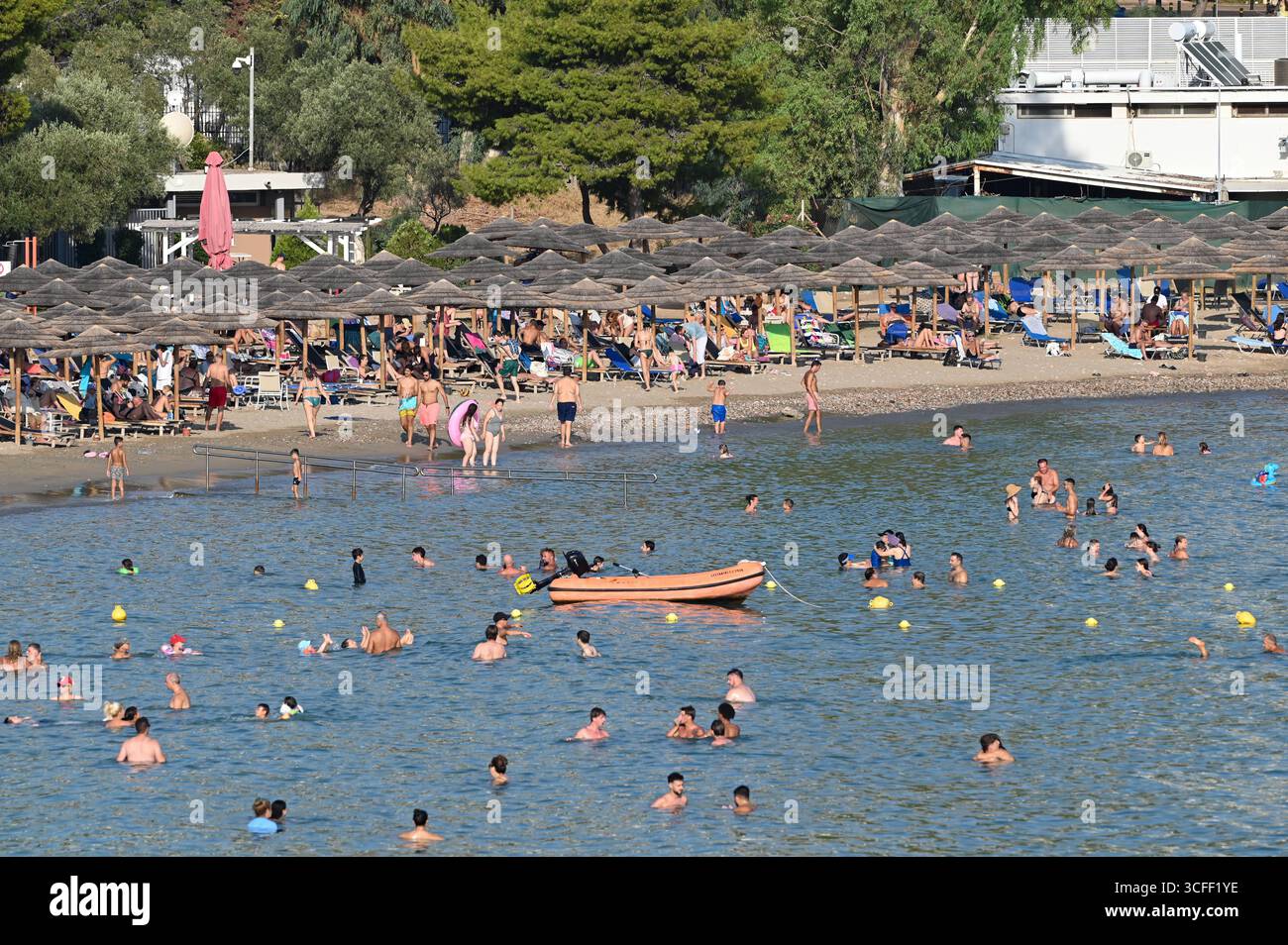 Folle di persone si recano sulle spiagge mentre una mini ondata di calore colpisce Atene folle di persone cercano di rinfrescarsi sulla spiaggia di Vouliagmeni vicino ad Atene mentre una mini ondata di calore colpisce la Grecia. Atene Grecia Copyright: XNicolasxKoutsokostasxNicolasxKoutsokostasx DSC 202508220644 Foto Stock