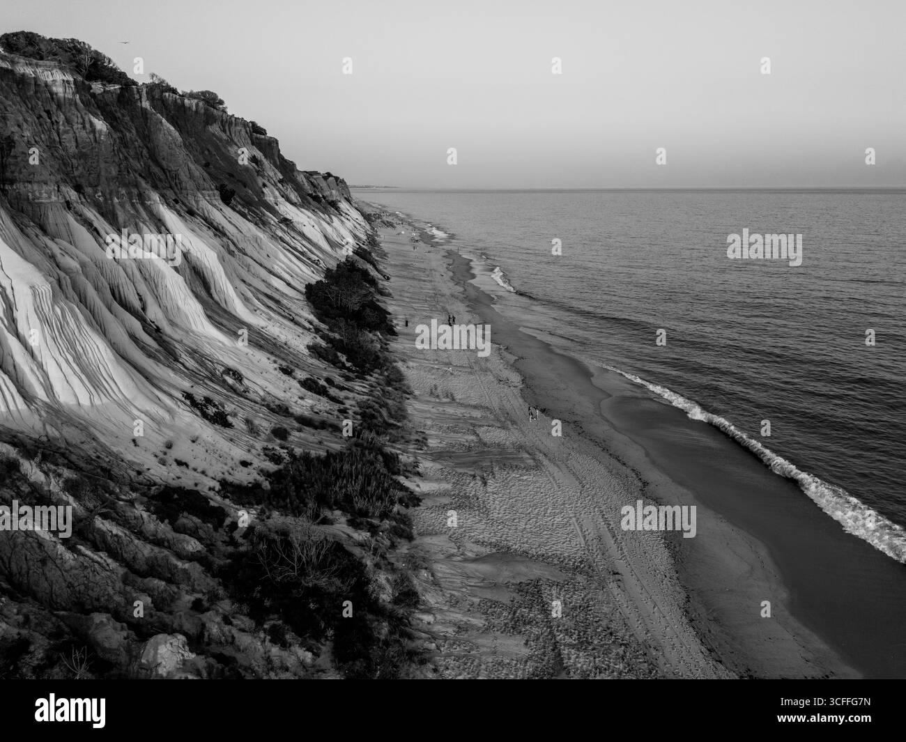 Praia da Falesia, Algarve, Portogallo – 2025.07.02 – spettacolari scogliere rosse e bianche che brillano al tramonto lungo la costa sabbiosa con dolci onde del Foto Stock