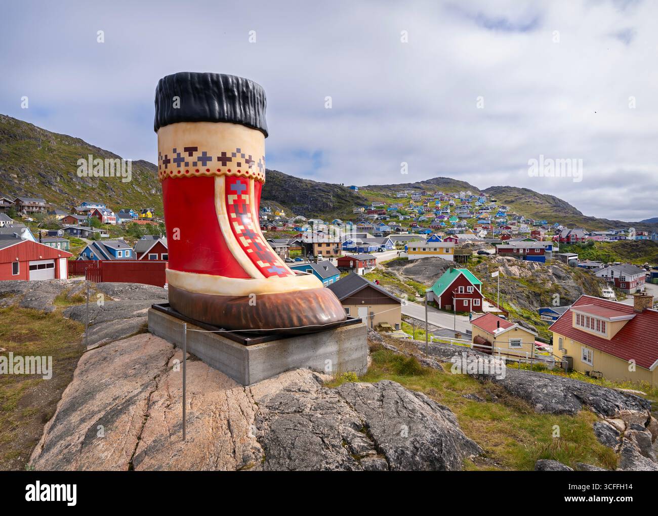 Grande stivale Inuit rosso sulla cima di una collina a Qaqortoq, in Groenlandia. Foto Stock