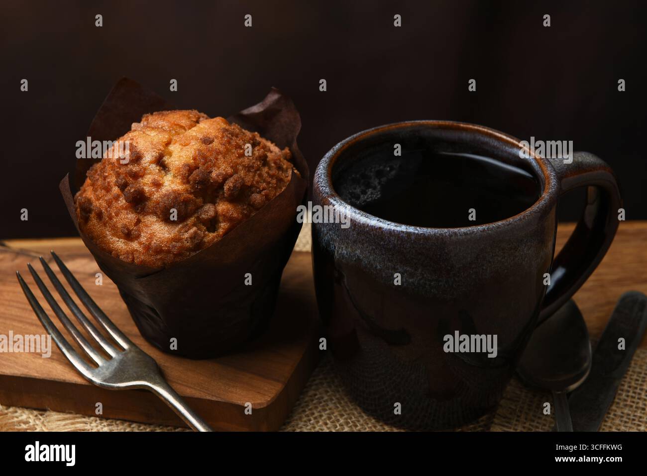 Una tazza di caffe' con muffin appena sfornato su un tavolo da caffe'. Foto Stock