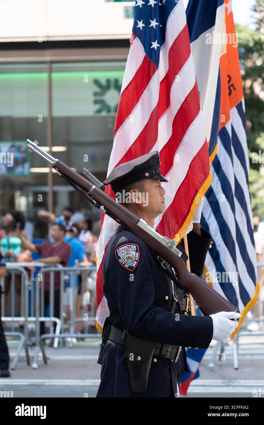 Una folla di spettatori tifa i partecipanti alla Parata Nazionale Dominicana del 2025 sulla 6th Avenue a New York. Gli agenti del Dipartimento delle correzioni stanno marciando nella parata. Foto Stock