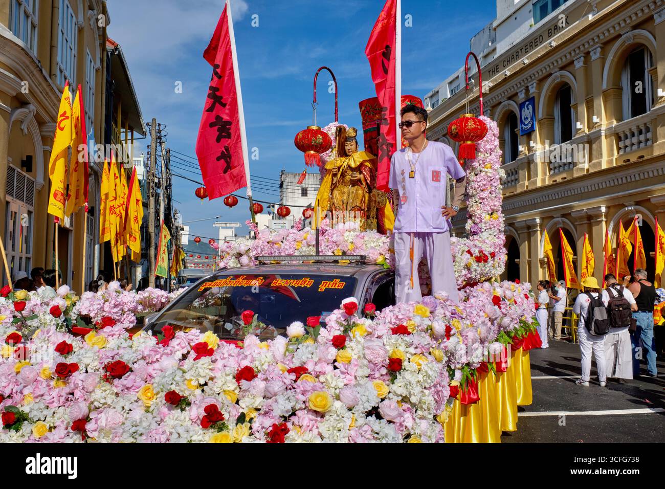 Un'auto trasformata in un galleggiante di fiori, in una sfilata durante il Festival vegetariano nella città di Phuket, Thailandia, sormontata da una statua di una dea taoista Foto Stock