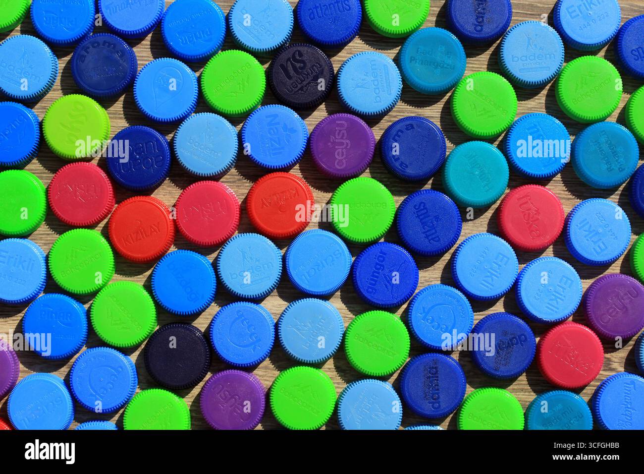 Tappi per bottiglie d'acqua in plastica di diversi colori. Materiali riciclabili in plastica colorata. Foto Stock