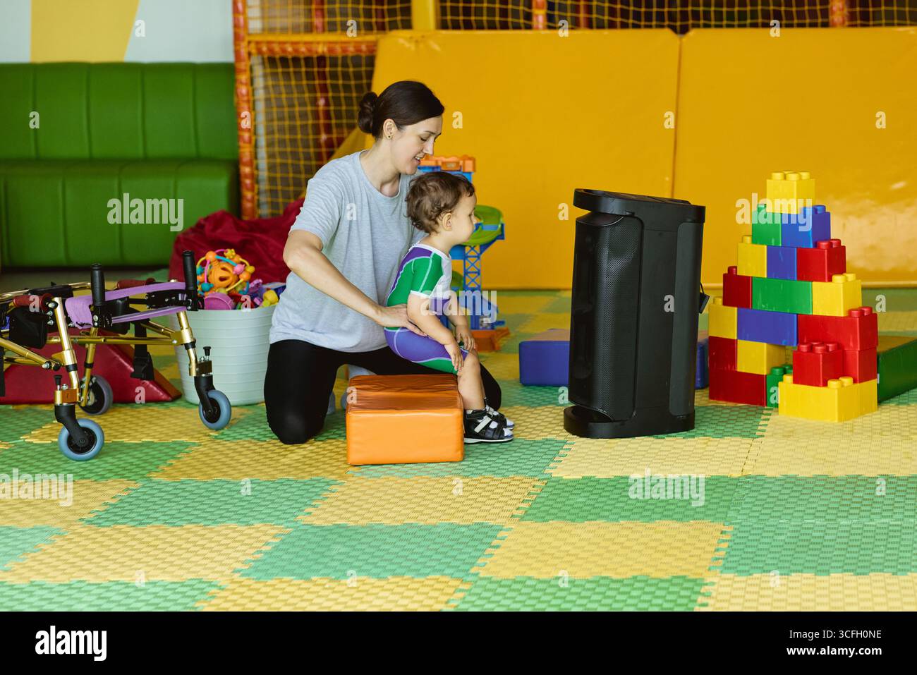 Fisioterapista donna che lavora con il bambino sulle capacità motorie e il coordinamento nella clinica di riabilitazione Foto Stock