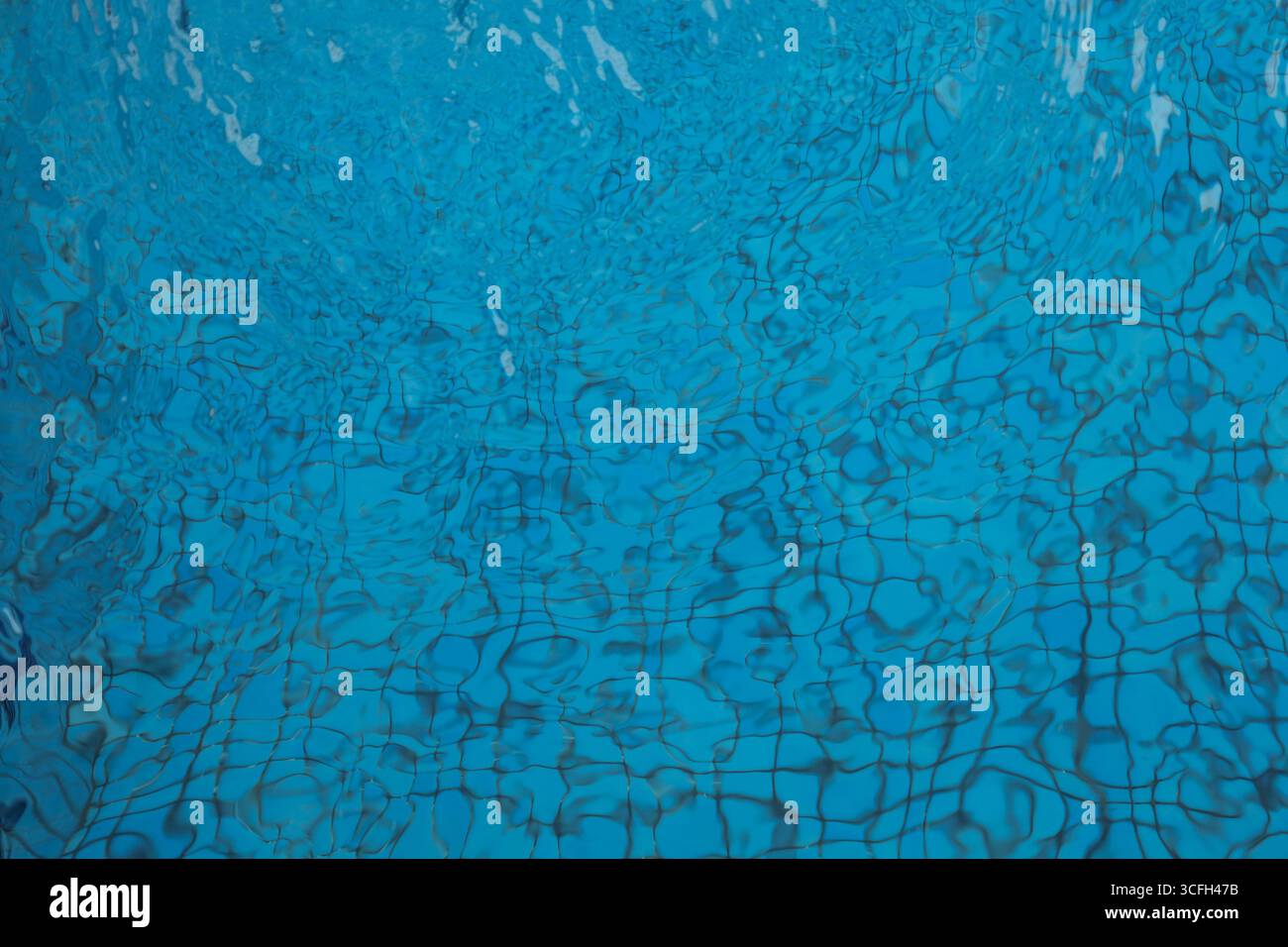 Primo piano della superficie dell'acqua in una piscina con increspature naturali e distorsioni di luce che formano un disegno astratto dinamico. Ideale per sfondi, texture, o. Foto Stock