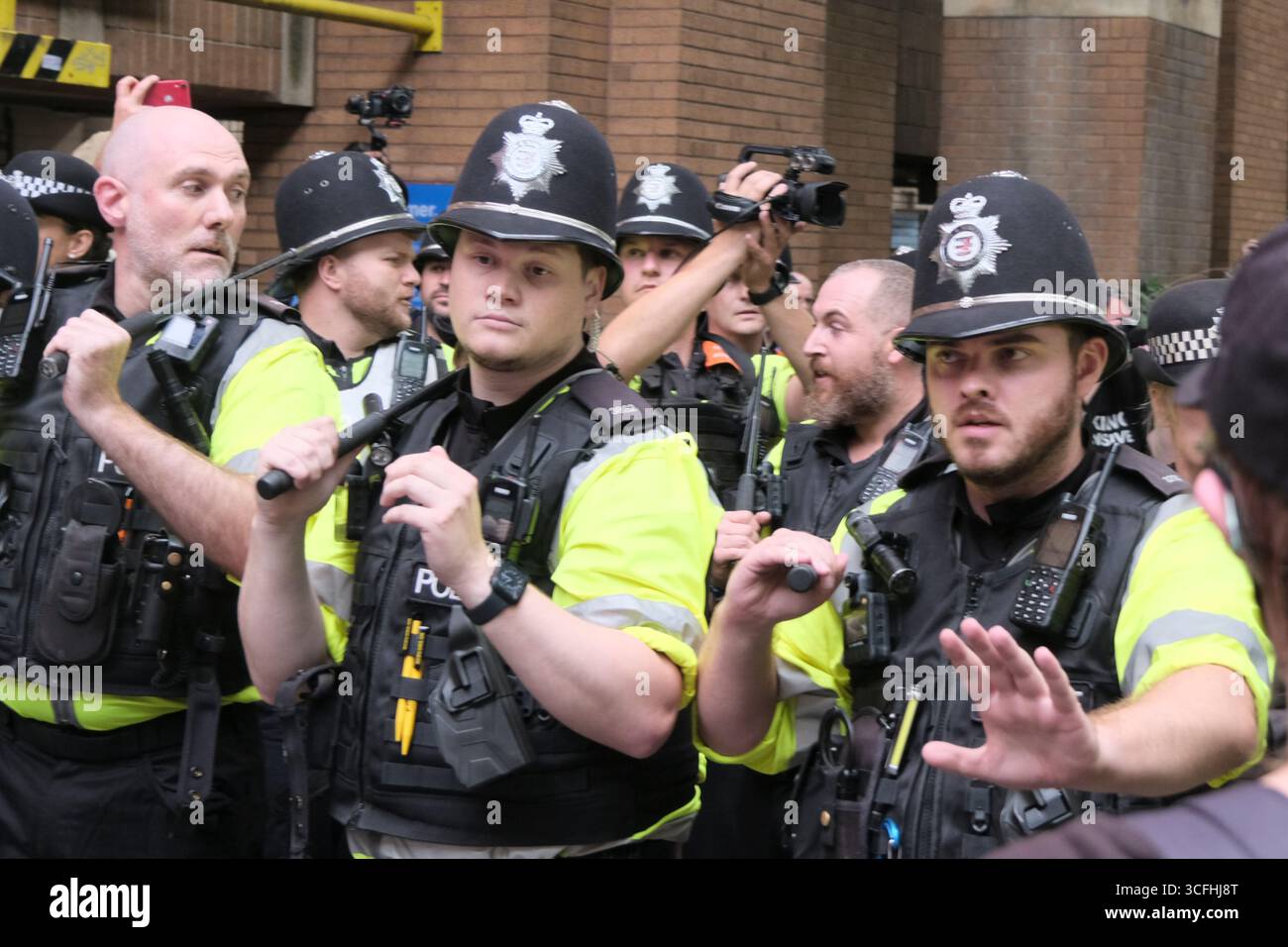 Bristol, Regno Unito. 23 agosto 2025. I manifestanti antifascisti e di estrema destra contro l'immigrazione di Bristol si sono urlati l'un l'altro tutto il pomeriggio a Castle Park Bristol, la polizia ha cercato di tenerli separati. Mentre l’estrema destra o i patrioti britannici cercavano di lasciare gli antifascisti li circondavano. La polizia era obbligata a prendere dei bastoni per tenere separate le due proteste. Crediti: JMF News/Alamy Live News Foto Stock