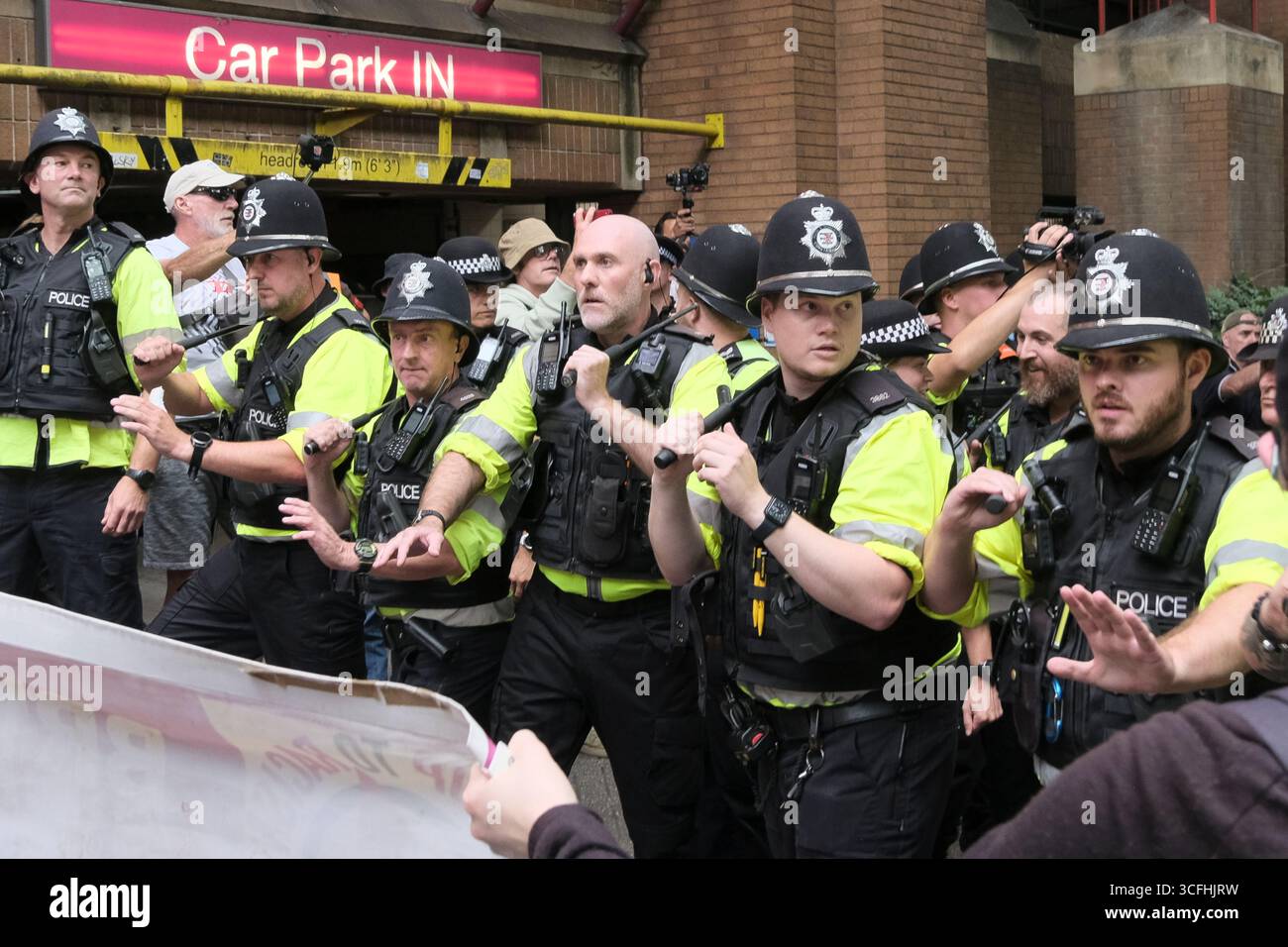 Bristol, Regno Unito. 23 agosto 2025. I manifestanti antifascisti e di estrema destra contro l'immigrazione di Bristol si sono urlati l'un l'altro tutto il pomeriggio a Castle Park Bristol, la polizia ha cercato di tenerli separati. Mentre l’estrema destra o i patrioti britannici cercavano di lasciare gli antifascisti li circondavano. La polizia era obbligata a prendere dei bastoni per tenere separate le due proteste. Crediti: JMF News/Alamy Live News Foto Stock