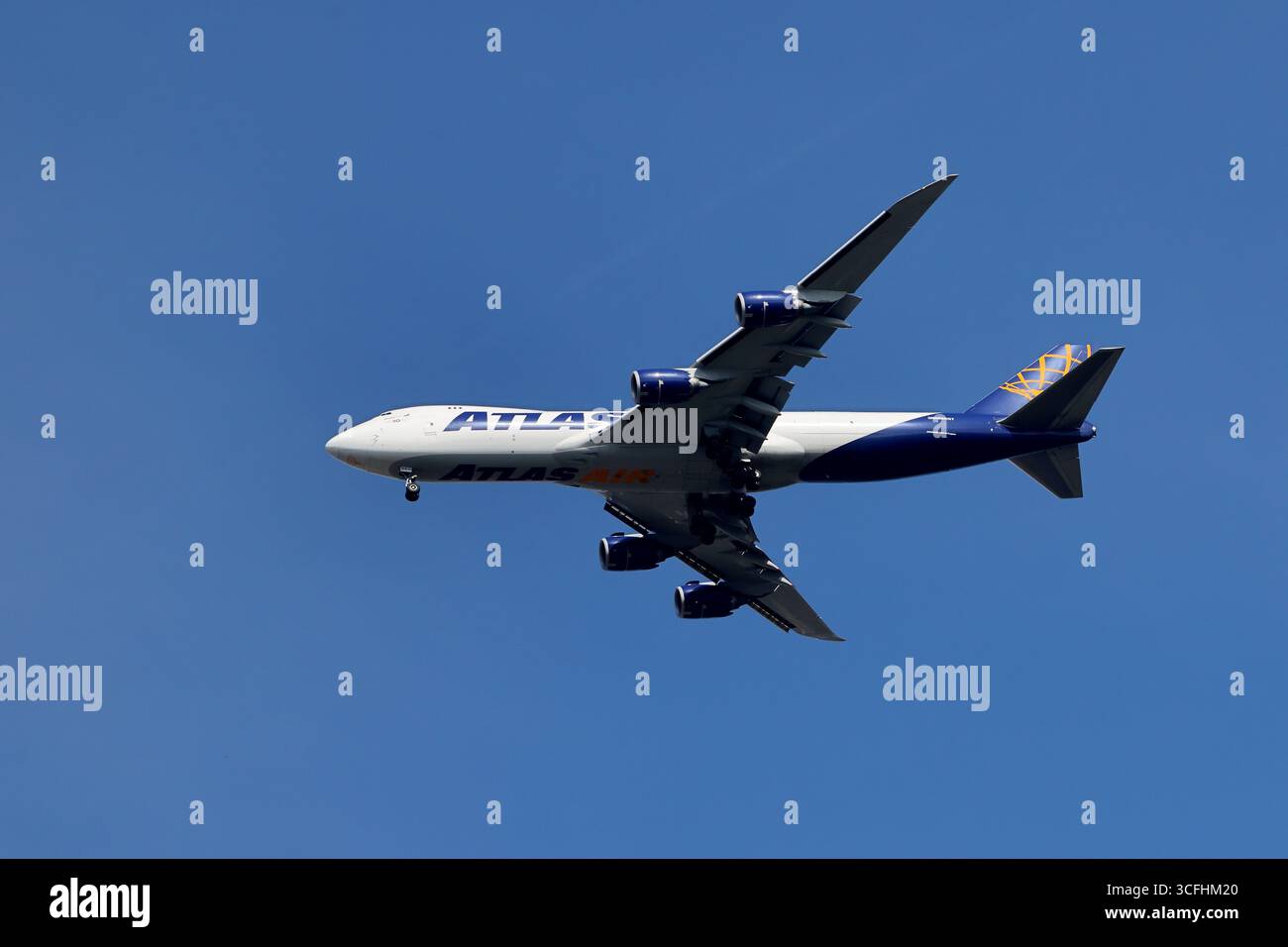 Atlas Air Boeing 747-400F in avvicinamento su Schiphol, Paesi Bassi, cargo wide-body con quattro motori e carrello di atterraggio in giù in luce blu brillante. Foto Stock