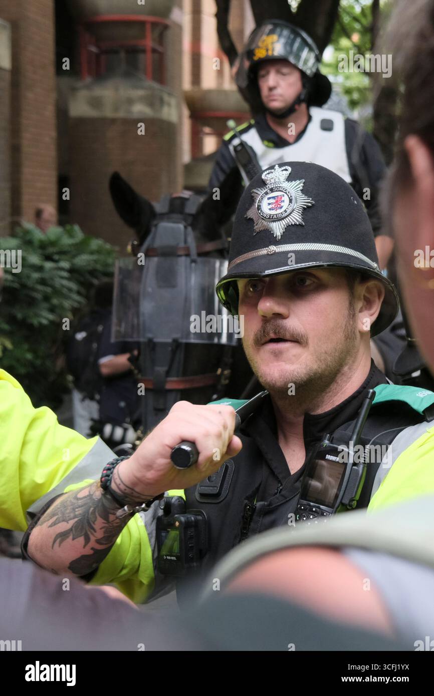 Bristol, Regno Unito. 23 agosto 2025. I manifestanti antifascisti e di estrema destra contro l'immigrazione di Bristol si sono urlati l'un l'altro tutto il pomeriggio a Castle Park Bristol, la polizia ha cercato di tenerli separati. Mentre l’estrema destra o i patrioti britannici cercavano di lasciare gli antifascisti li circondavano. La polizia era obbligata a prendere dei bastoni per tenere separate le due proteste. Crediti: JMF News/Alamy Live News Foto Stock