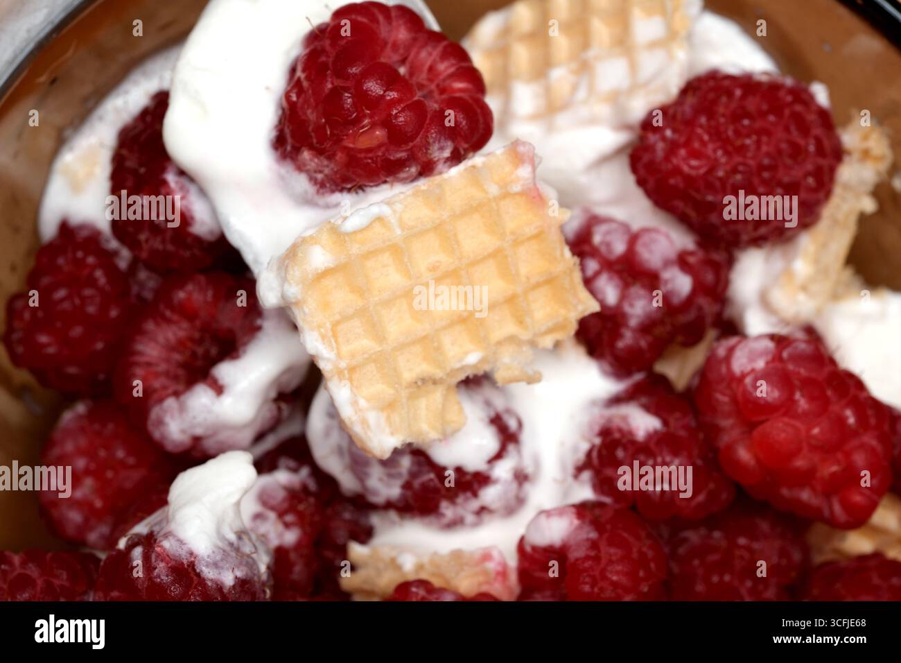 Lamponi, cremoso condimento e cialde croccanti creano una delizia gustosa! Foto Stock