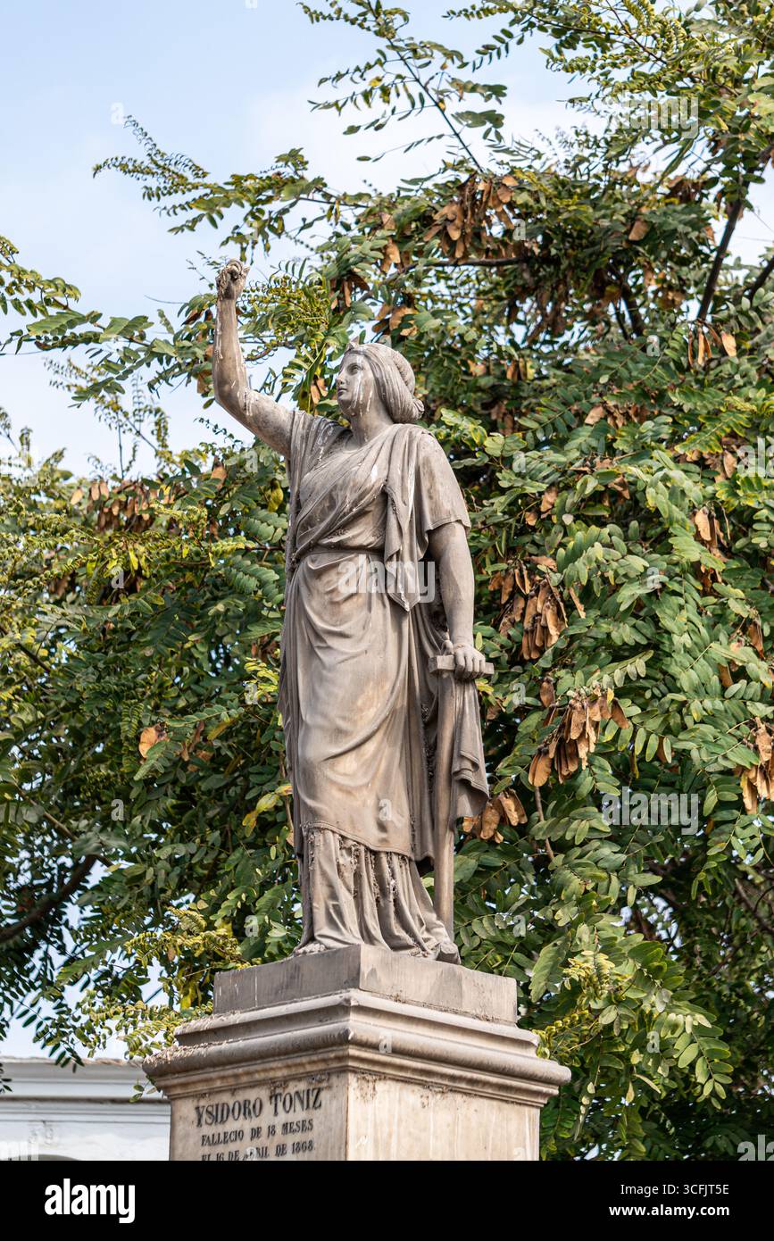 Classica statua funeraria femminile che tiene la corona tra gli alberi al cimitero Presbitero Maestro di Lima in Perù Foto Stock