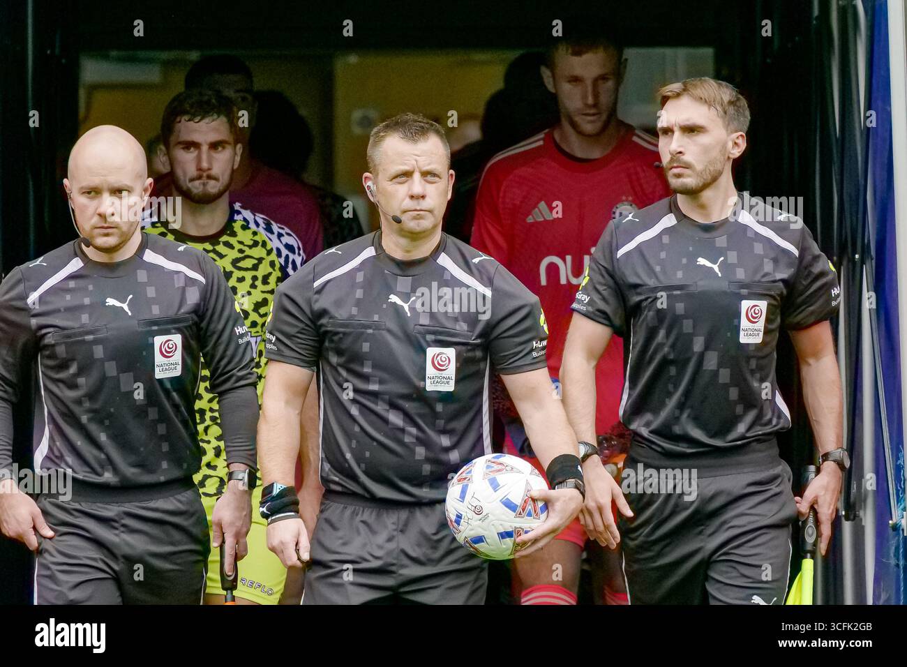 Halifax, Regno Unito. 23 agosto 2025. Gli ufficiali della partita (Gareth Rhodes, David Holmes e Michael Robinson) e le squadre emergono dal tunnel. L'FC Halifax Town gioca contro i Forest Green Rovers giocando in una partita della stagione 2025-2026 dell'Enterprise National League allo Shay Stadium di Halifax, West Yorkshire. Crediti: SpImageryBT / Alamy Live News Foto Stock