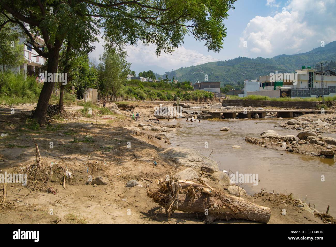 Fiume SWAT vicino a Mingora, trasformato da inondazioni con maggiore profondità e sponde restaurate. Una scena naturale spettacolare con vegetazione lussureggiante, perfetta per Foto Stock