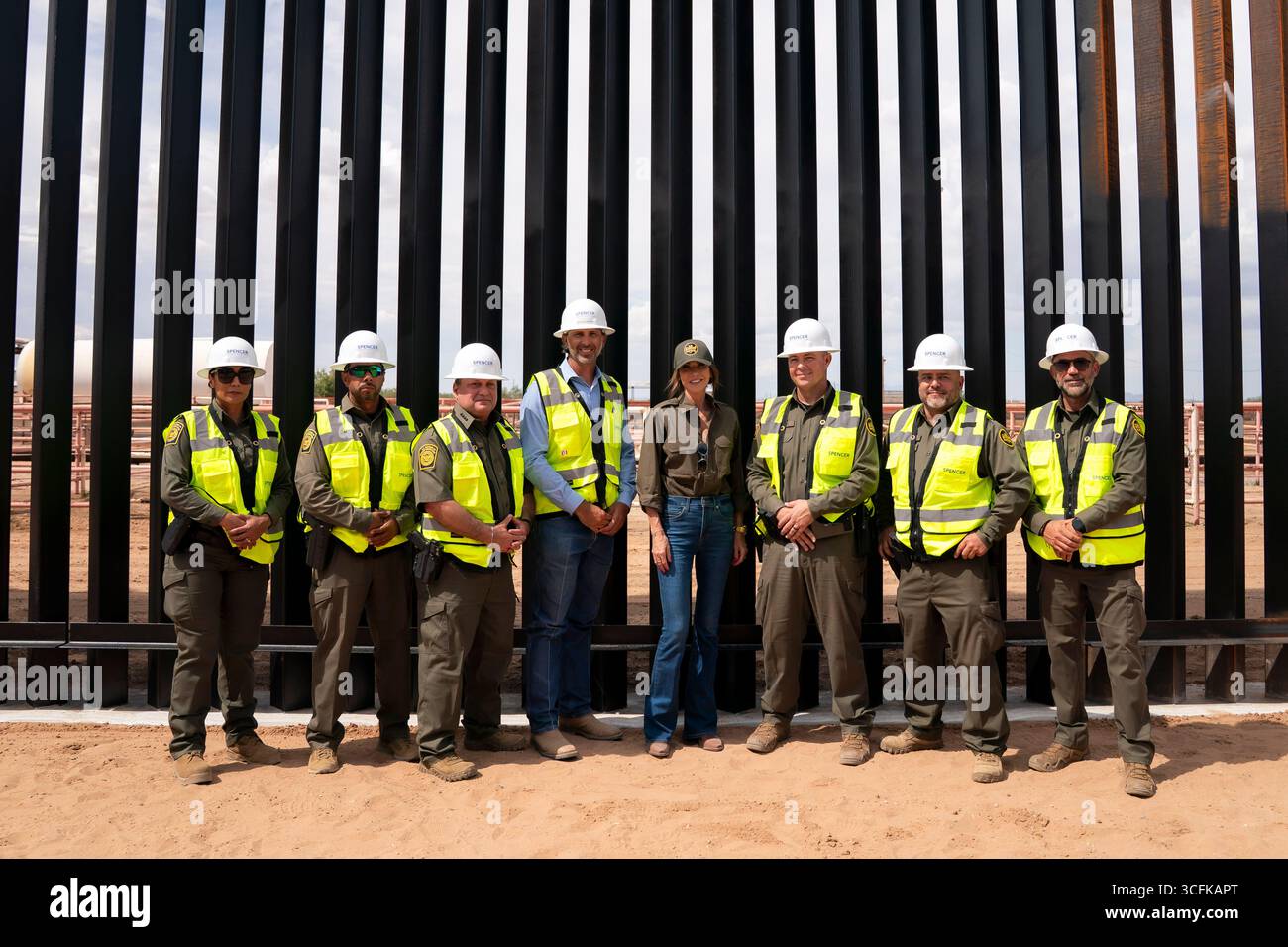 Il segretario del Dipartimento per la sicurezza interna (DHS) Kristi Noem ha viaggiato su un jet militare e poi su un elicottero fino al muro del confine meridionale degli Stati Uniti, dove ha in mano una foto - sotto la direzione del presidente Donald Trump - per dipingere il muro d'acciaio del confine nero a Santa Teresa, New Mexico. Noem è stato assistito da membri in uniforme degli agenti della dogana e della protezione delle frontiere degli Stati Uniti. La vernice nera doveva raccogliere l’energia del sole per rendere l’acciaio del muro più caldo al tatto – quindi più difficile per i clandestini scalare. La vernice, tuttavia, veniva applicata solo sul lato statunitense del muro di confine. Foto Stock