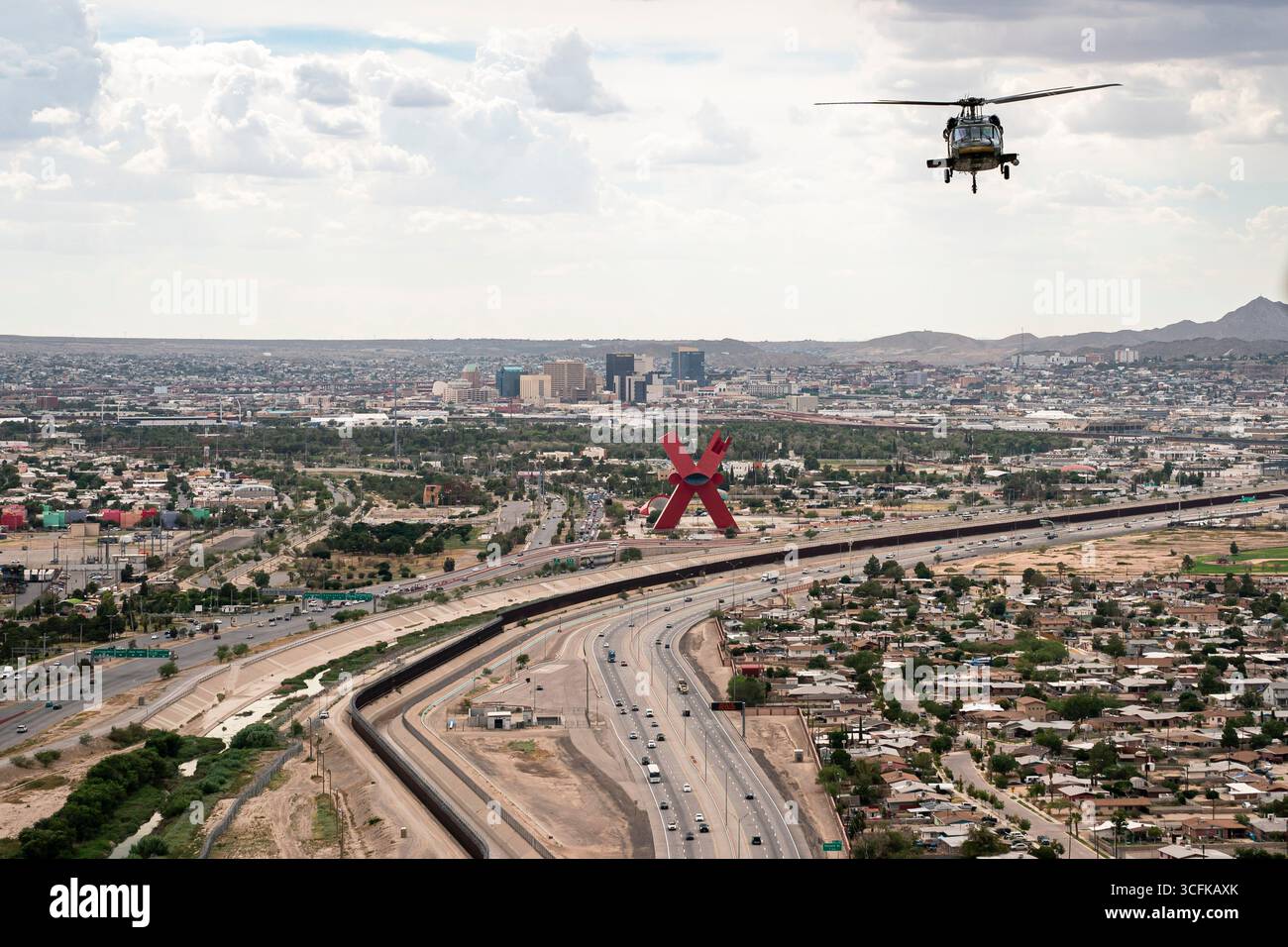 Il segretario del Dipartimento per la sicurezza interna (DHS) Kristi Noem ha viaggiato su un jet militare e poi su un elicottero fino al muro del confine meridionale degli Stati Uniti, dove ha in mano una foto - sotto la direzione del presidente Donald Trump - per dipingere il muro d'acciaio del confine nero a Santa Teresa, New Mexico. Noem è stato assistito da membri in uniforme degli agenti della dogana e della protezione delle frontiere degli Stati Uniti. La vernice nera doveva raccogliere l’energia del sole per rendere l’acciaio del muro più caldo al tatto – quindi più difficile per i clandestini scalare. La vernice, tuttavia, veniva applicata solo sul lato statunitense del muro di confine. Foto Stock