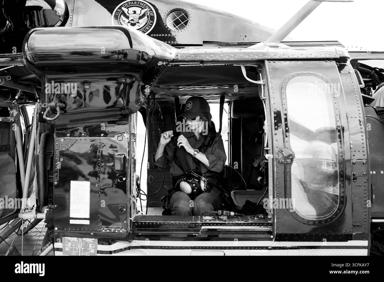 Il segretario del Dipartimento per la sicurezza interna (DHS) Kristi Noem ha viaggiato su un jet militare e poi su un elicottero fino al muro del confine meridionale degli Stati Uniti, dove ha in mano una foto - sotto la direzione del presidente Donald Trump - per dipingere il muro d'acciaio del confine nero a Santa Teresa, New Mexico. Noem è stato assistito da membri in uniforme degli agenti della dogana e della protezione delle frontiere degli Stati Uniti. La vernice nera doveva raccogliere l’energia del sole per rendere l’acciaio del muro più caldo al tatto – quindi più difficile per i clandestini scalare. La vernice, tuttavia, veniva applicata solo sul lato statunitense del muro di confine. Foto Stock