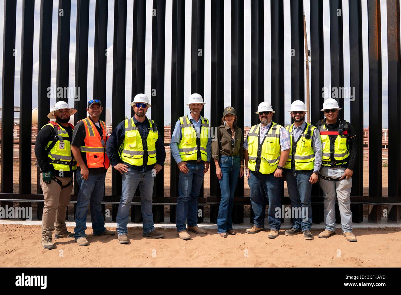 Il segretario del Dipartimento per la sicurezza interna (DHS) Kristi Noem ha viaggiato su un jet militare e poi su un elicottero fino al muro del confine meridionale degli Stati Uniti, dove ha in mano una foto - sotto la direzione del presidente Donald Trump - per dipingere il muro d'acciaio del confine nero a Santa Teresa, New Mexico. Noem è stato assistito da membri in uniforme degli agenti della dogana e della protezione delle frontiere degli Stati Uniti. La vernice nera doveva raccogliere l’energia del sole per rendere l’acciaio del muro più caldo al tatto – quindi più difficile per i clandestini scalare. La vernice, tuttavia, veniva applicata solo sul lato statunitense del muro di confine. Foto Stock