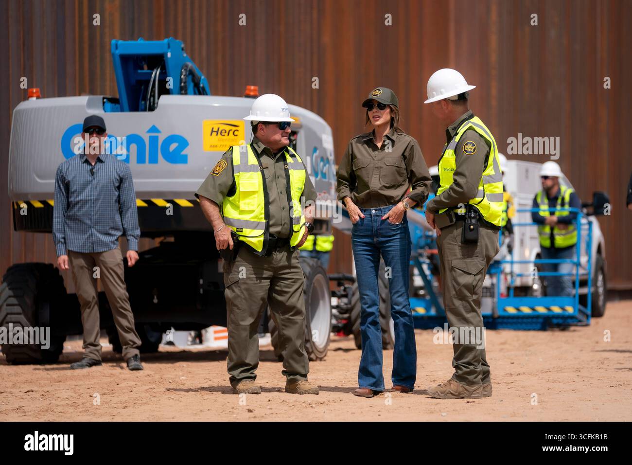 Il segretario del Dipartimento per la sicurezza interna (DHS) Kristi Noem ha viaggiato su un jet militare e poi su un elicottero fino al muro del confine meridionale degli Stati Uniti, dove ha in mano una foto - sotto la direzione del presidente Donald Trump - per dipingere il muro d'acciaio del confine nero a Santa Teresa, New Mexico. Noem è stato assistito da membri in uniforme degli agenti della dogana e della protezione delle frontiere degli Stati Uniti. La vernice nera doveva raccogliere l’energia del sole per rendere l’acciaio del muro più caldo al tatto – quindi più difficile per i clandestini scalare. La vernice, tuttavia, veniva applicata solo sul lato statunitense del muro di confine. Foto Stock