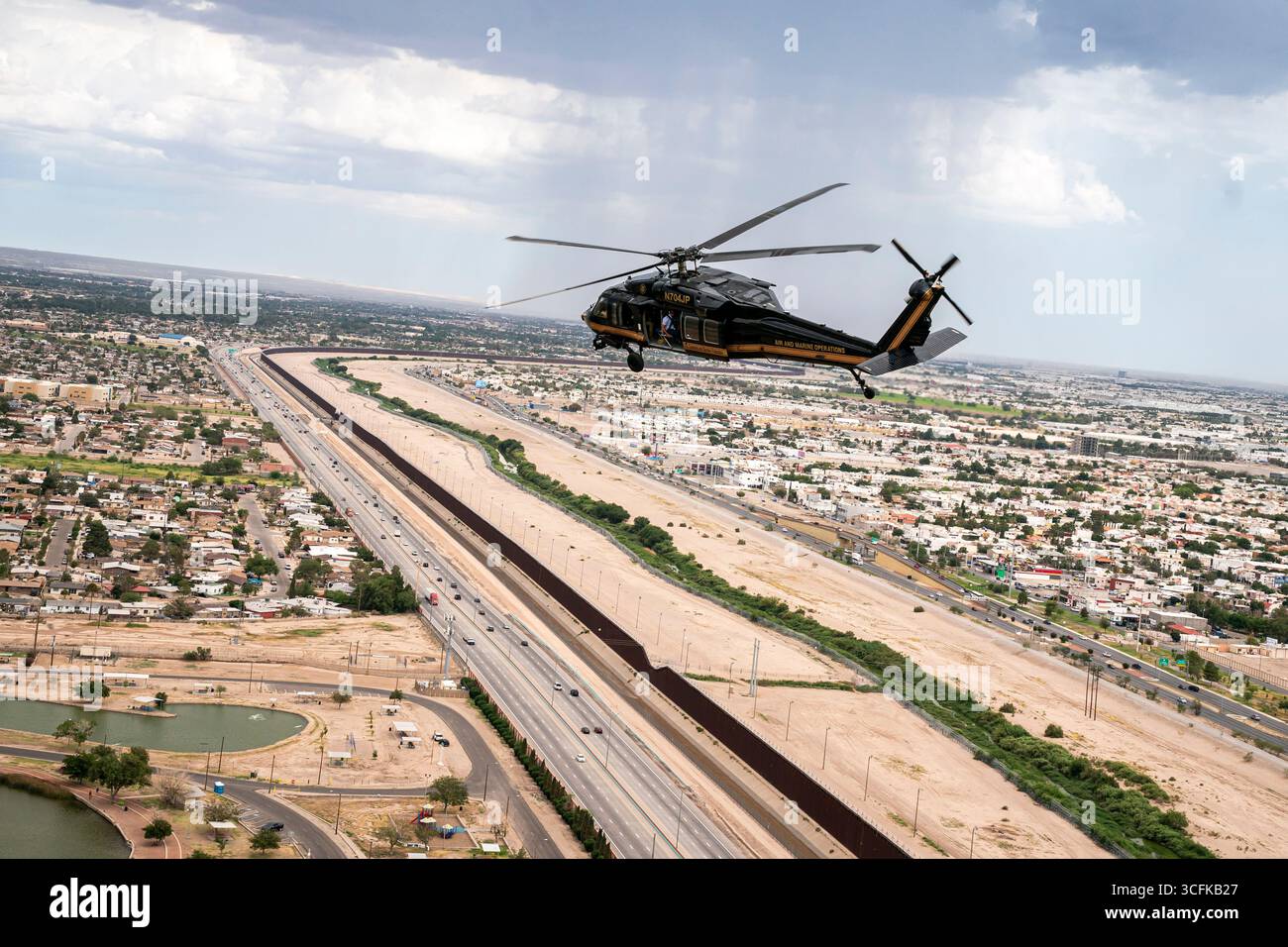 Il segretario del Dipartimento per la sicurezza interna (DHS) Kristi Noem ha viaggiato su un jet militare e poi su un elicottero fino al muro del confine meridionale degli Stati Uniti, dove ha in mano una foto - sotto la direzione del presidente Donald Trump - per dipingere il muro d'acciaio del confine nero a Santa Teresa, New Mexico. Noem è stato assistito da membri in uniforme degli agenti della dogana e della protezione delle frontiere degli Stati Uniti. La vernice nera doveva raccogliere l’energia del sole per rendere l’acciaio del muro più caldo al tatto – quindi più difficile per i clandestini scalare. La vernice, tuttavia, veniva applicata solo sul lato statunitense del muro di confine. Foto Stock