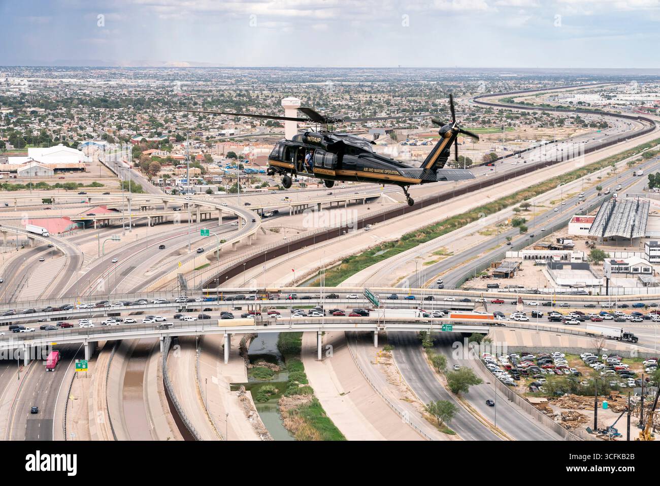 Il segretario del Dipartimento per la sicurezza interna (DHS) Kristi Noem ha viaggiato su un jet militare e poi su un elicottero fino al muro del confine meridionale degli Stati Uniti, dove ha in mano una foto - sotto la direzione del presidente Donald Trump - per dipingere il muro d'acciaio del confine nero a Santa Teresa, New Mexico. Noem è stato assistito da membri in uniforme degli agenti della dogana e della protezione delle frontiere degli Stati Uniti. La vernice nera doveva raccogliere l’energia del sole per rendere l’acciaio del muro più caldo al tatto – quindi più difficile per i clandestini scalare. La vernice, tuttavia, veniva applicata solo sul lato statunitense del muro di confine. Foto Stock