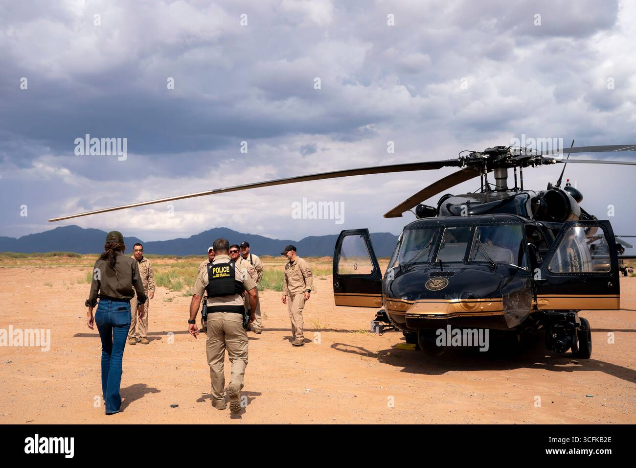Il segretario del Dipartimento per la sicurezza interna (DHS) Kristi Noem ha viaggiato su un jet militare e poi su un elicottero fino al muro del confine meridionale degli Stati Uniti, dove ha in mano una foto - sotto la direzione del presidente Donald Trump - per dipingere il muro d'acciaio del confine nero a Santa Teresa, New Mexico. Noem è stato assistito da membri in uniforme degli agenti della dogana e della protezione delle frontiere degli Stati Uniti. La vernice nera doveva raccogliere l’energia del sole per rendere l’acciaio del muro più caldo al tatto – quindi più difficile per i clandestini scalare. La vernice, tuttavia, veniva applicata solo sul lato statunitense del muro di confine. Foto Stock
