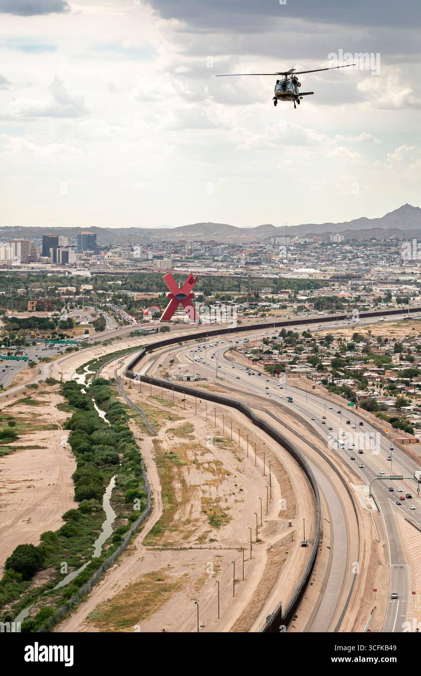 Il segretario del Dipartimento per la sicurezza interna (DHS) Kristi Noem ha viaggiato su un jet militare e poi su un elicottero fino al muro del confine meridionale degli Stati Uniti, dove ha in mano una foto - sotto la direzione del presidente Donald Trump - per dipingere il muro d'acciaio del confine nero a Santa Teresa, New Mexico. Noem è stato assistito da membri in uniforme degli agenti della dogana e della protezione delle frontiere degli Stati Uniti. La vernice nera doveva raccogliere l’energia del sole per rendere l’acciaio del muro più caldo al tatto – quindi più difficile per i clandestini scalare. La vernice, tuttavia, veniva applicata solo sul lato statunitense del muro di confine. Foto Stock