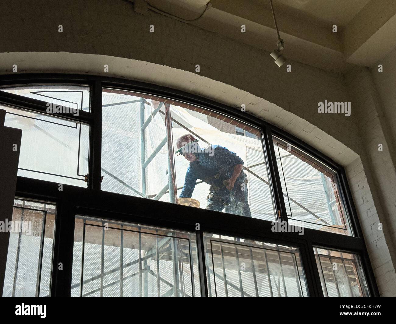 Operaio edile che ripara la facciata di un edificio, vista attraverso la finestra di un appartamento residenziale, Manhattan, New York, New York, Stati Uniti Foto Stock