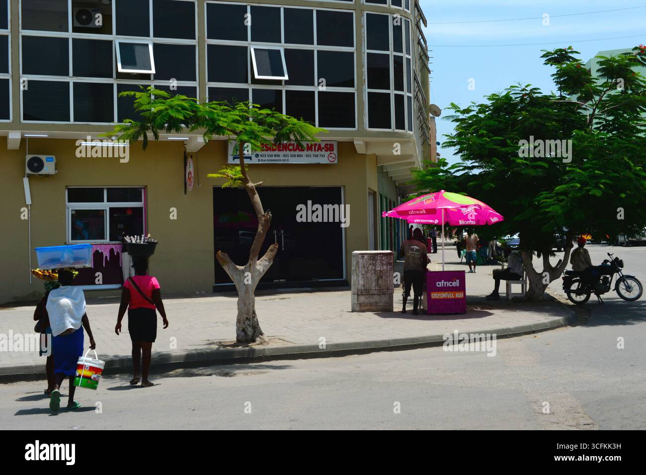 BENGUELA, ANGOLA - 13 febbraio 2025: Persone che camminano per la strada di Benguela. Tipica scena di strada Foto Stock